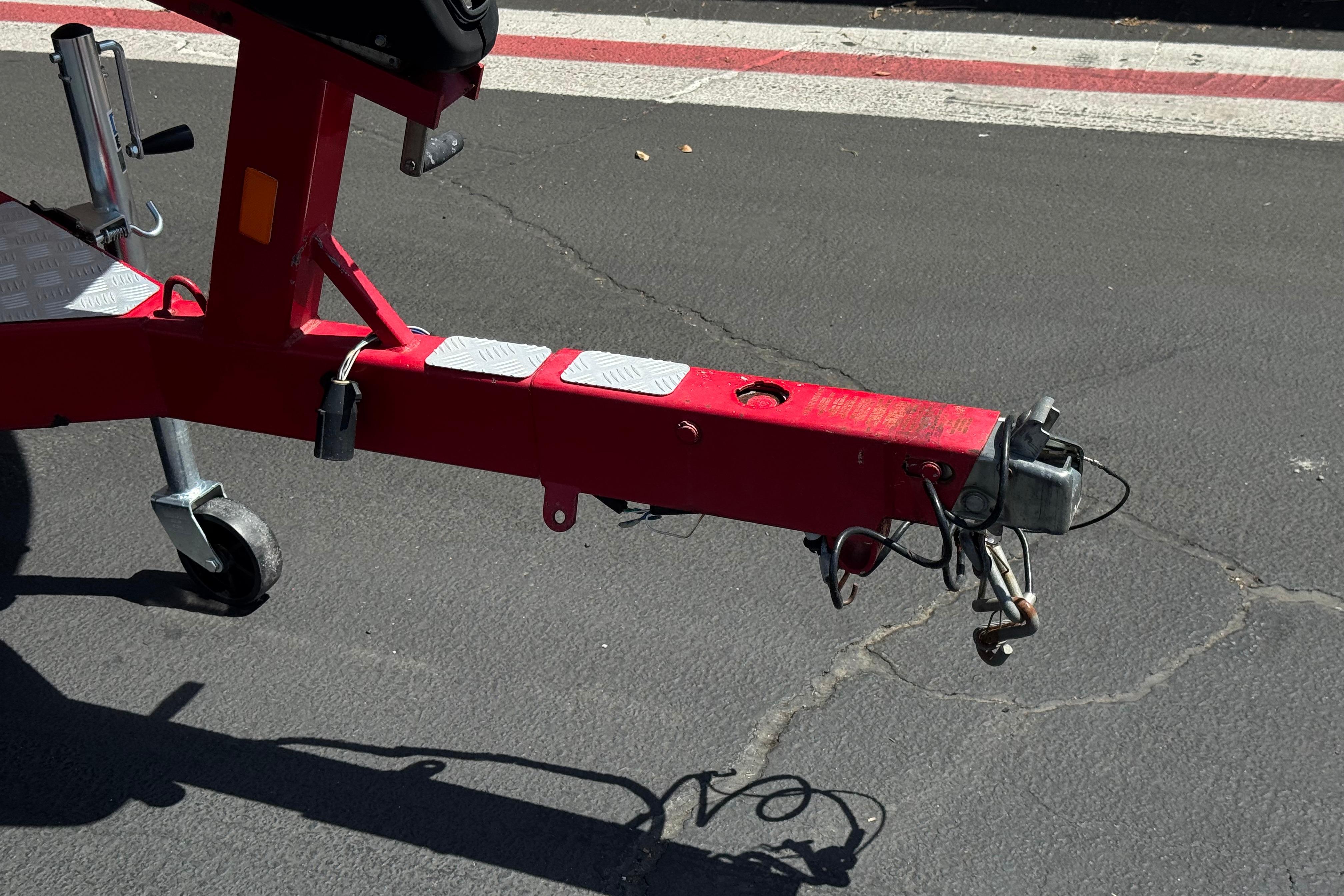 Red trailer hitch of a 2010 Bryant 255 on asphalt pavement.