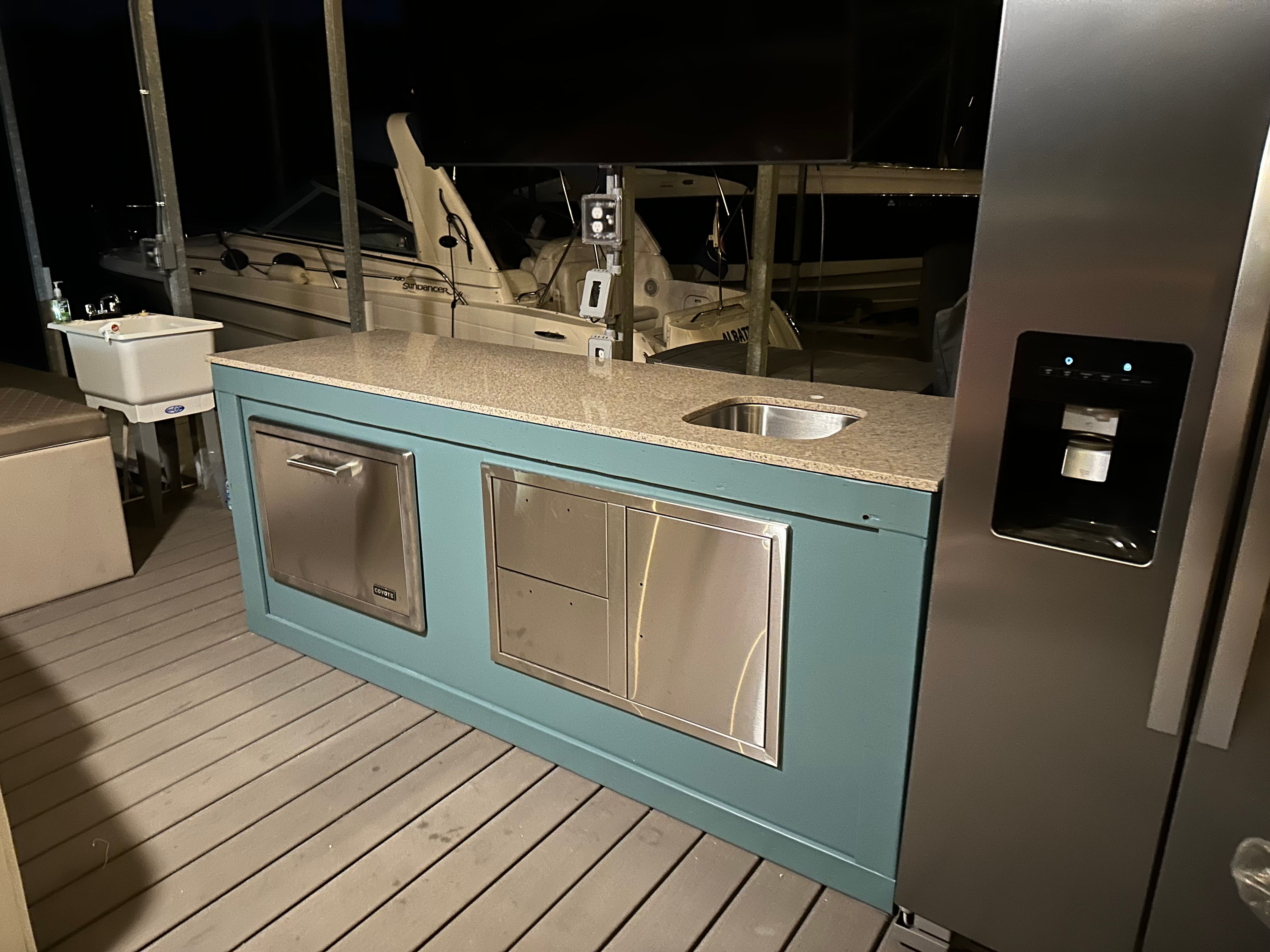 Carver 36 Mariner 2012 with modern outdoor kitchen and stainless steel appliances.