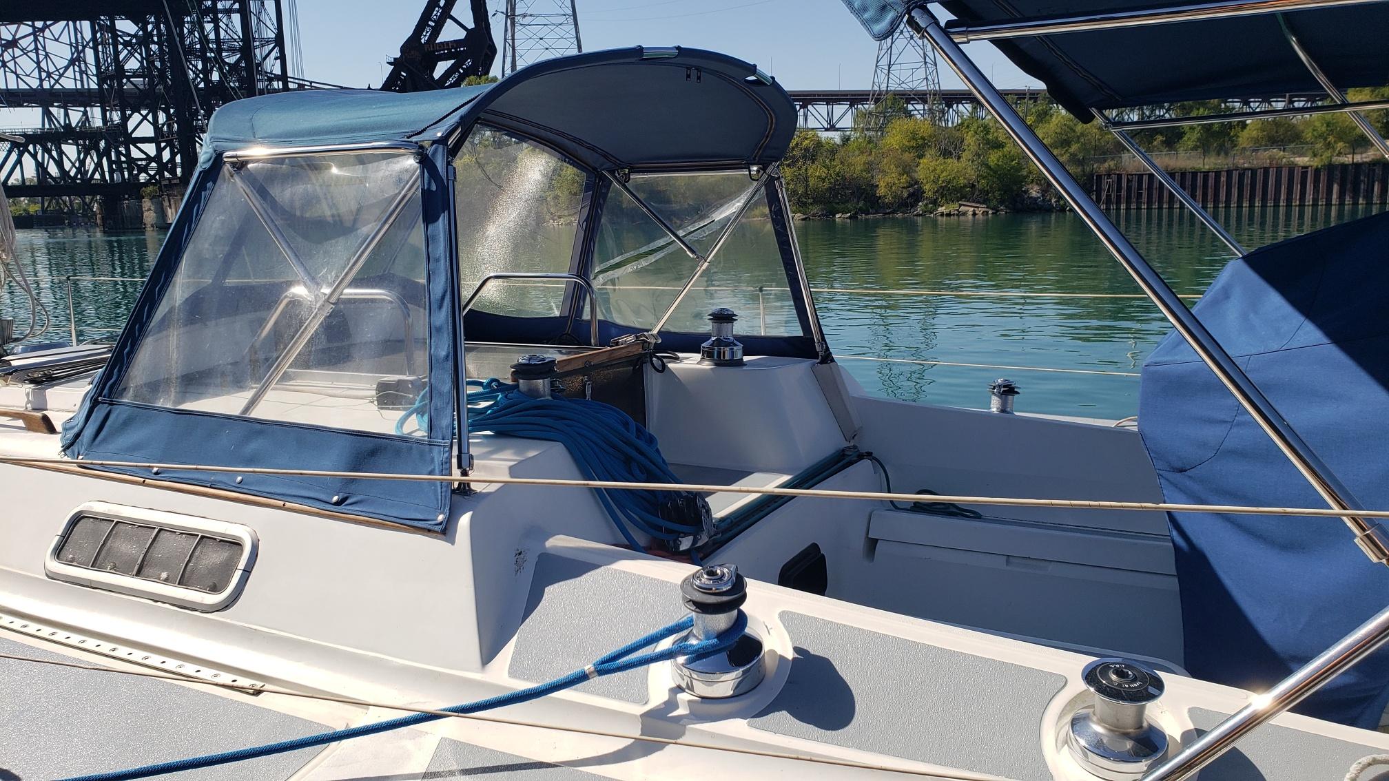 1989 Hunter Legend 37 sailboat with blue canopy, docked on a sunny day.