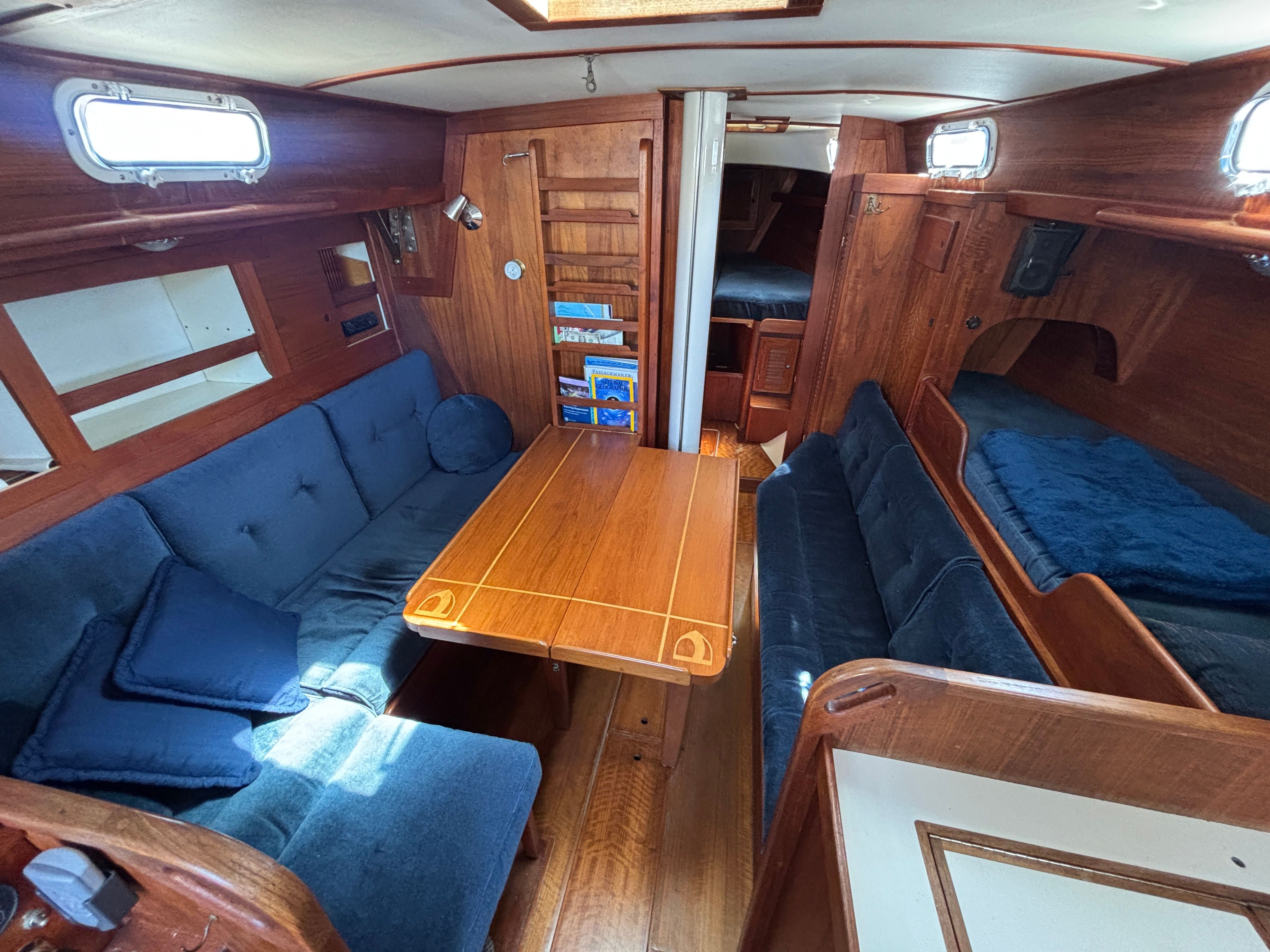 Interior of a 1979 Tartan 37 with wooden furnishings and blue upholstery.
