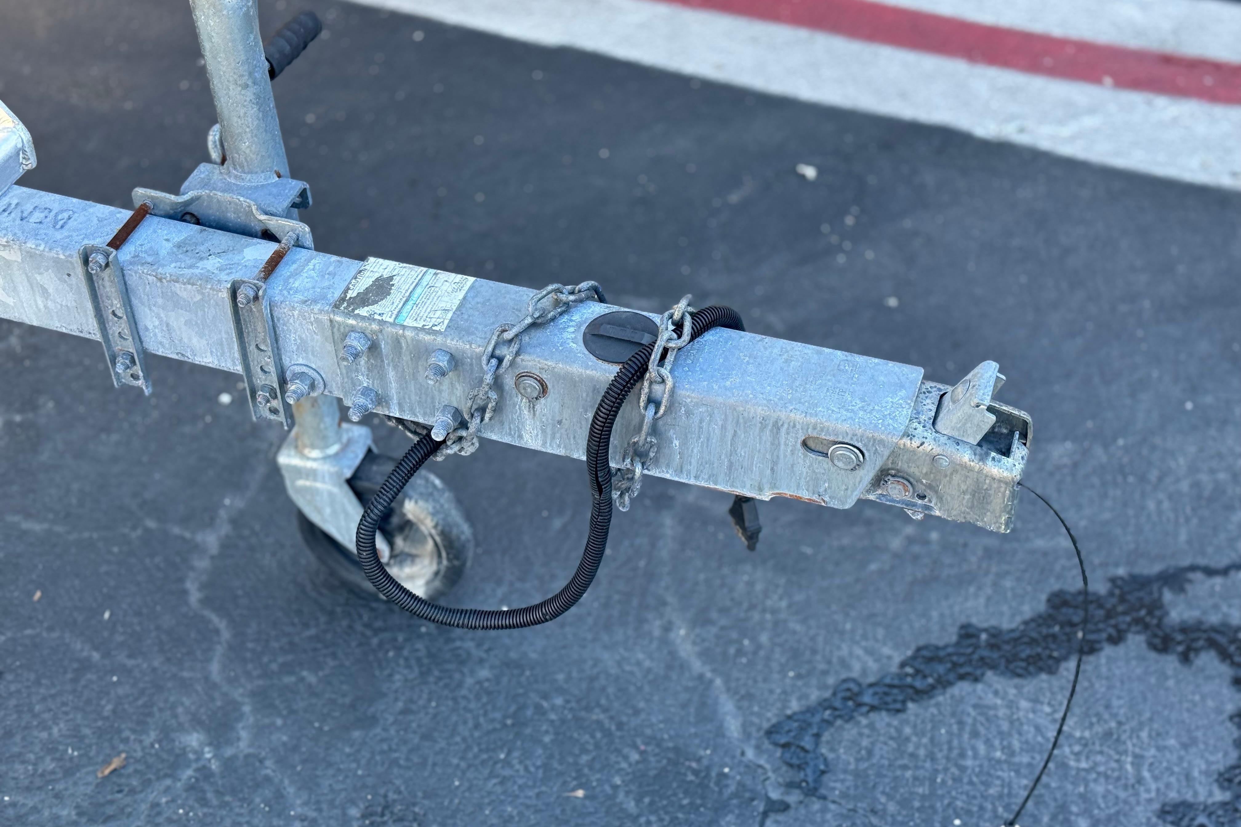 Trailer hitch of a 2013 Bennington 2575QCW I/O on asphalt surface.