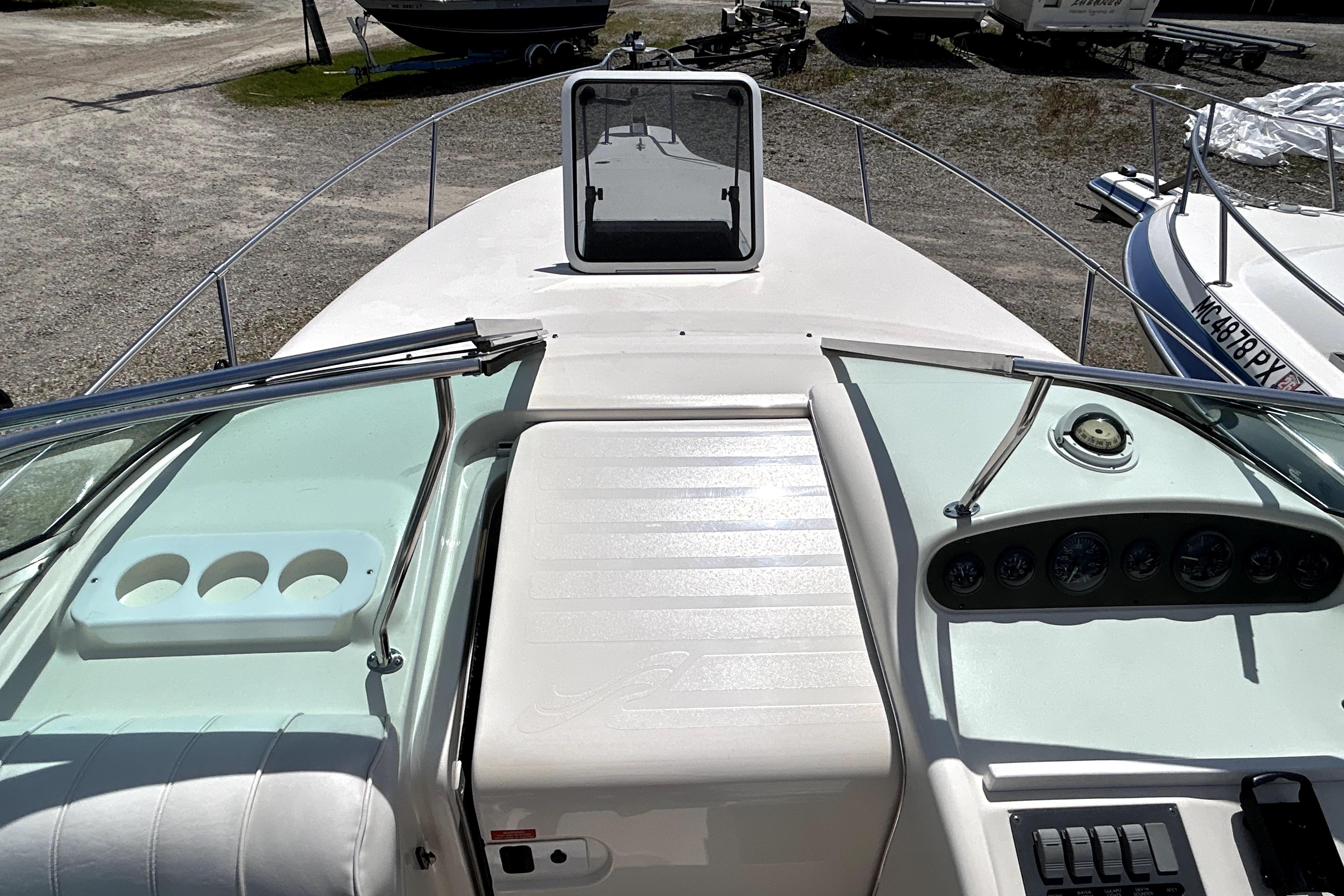 1995 Sea Ray 250 Sundancer boat dashboard with gauges and controls, docked outdoors.