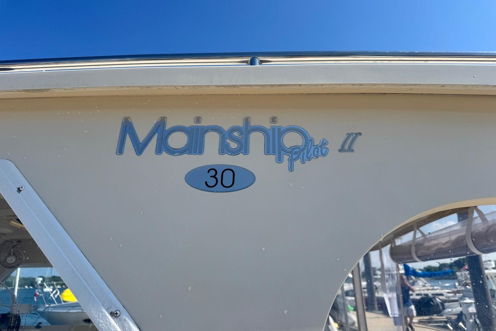 2004 Mainship Pilot 30-II boat side view with logo and model name.