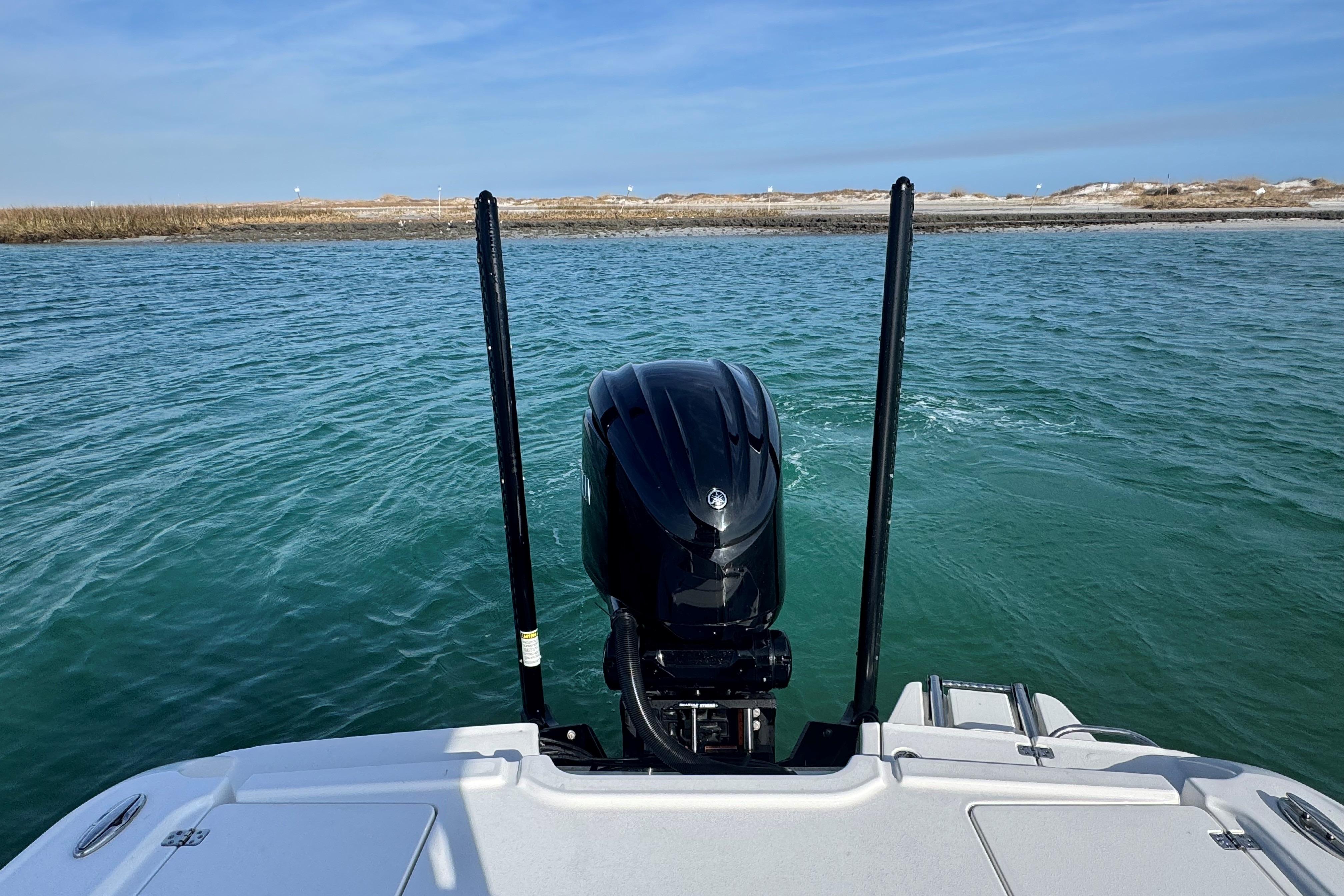 Crevalle 24 HCO 2025 boat on water, featuring powerful outboard motor.