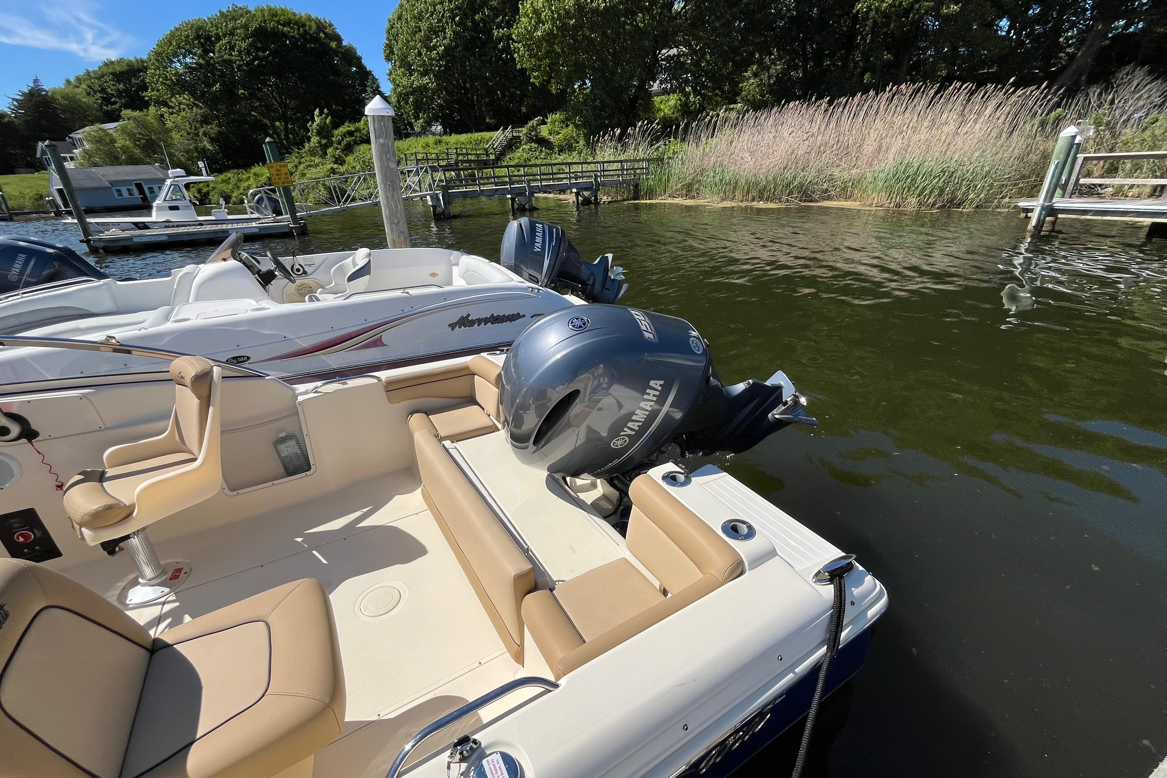 2017 Scout 210 Dorado boat with Yamaha engine docked by a serene lakeside.