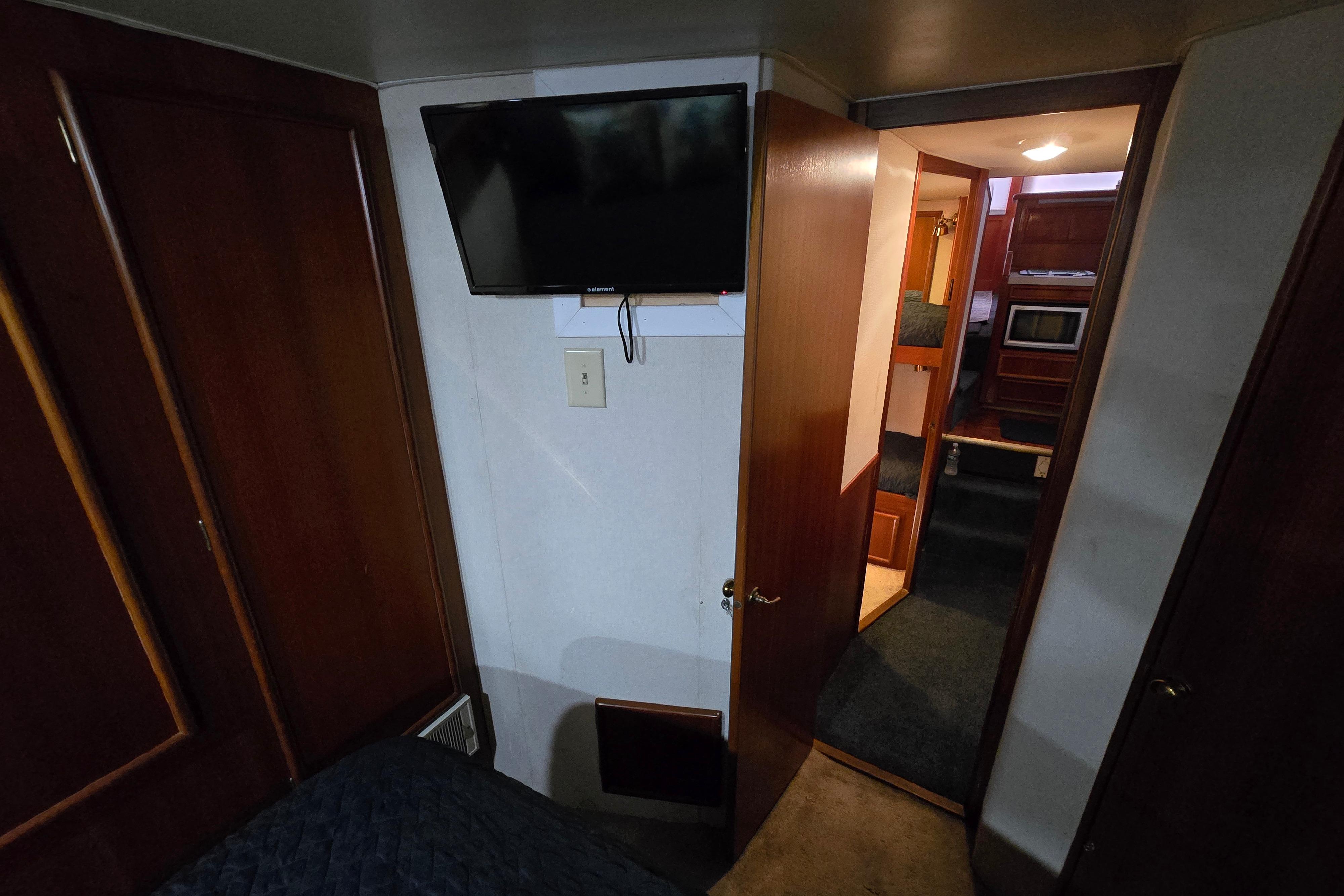 Interior of 1988 Post 46 Convertible yacht with TV and wooden cabinetry.