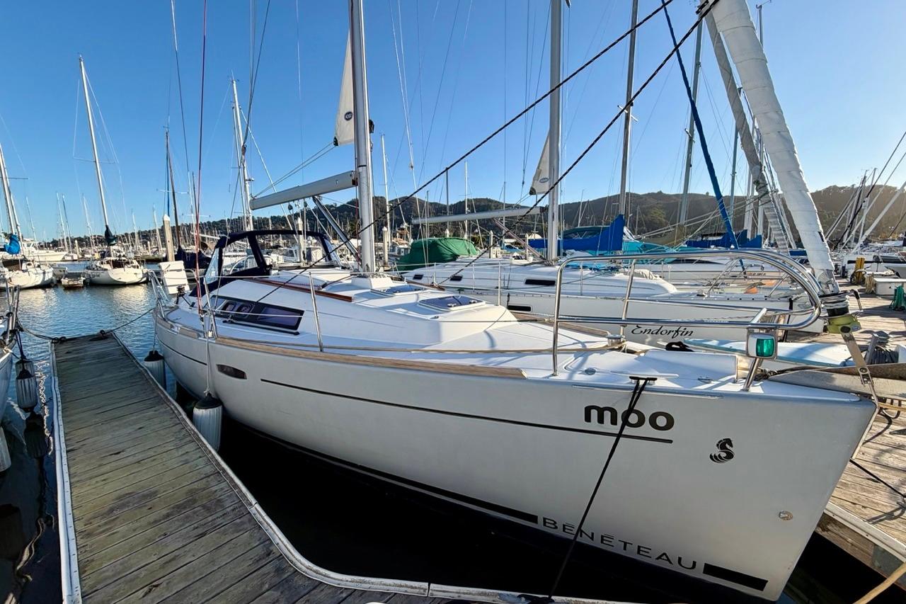 2014 Beneteau Oceanis 31 sailboat docked in a marina, surrounded by other boats.