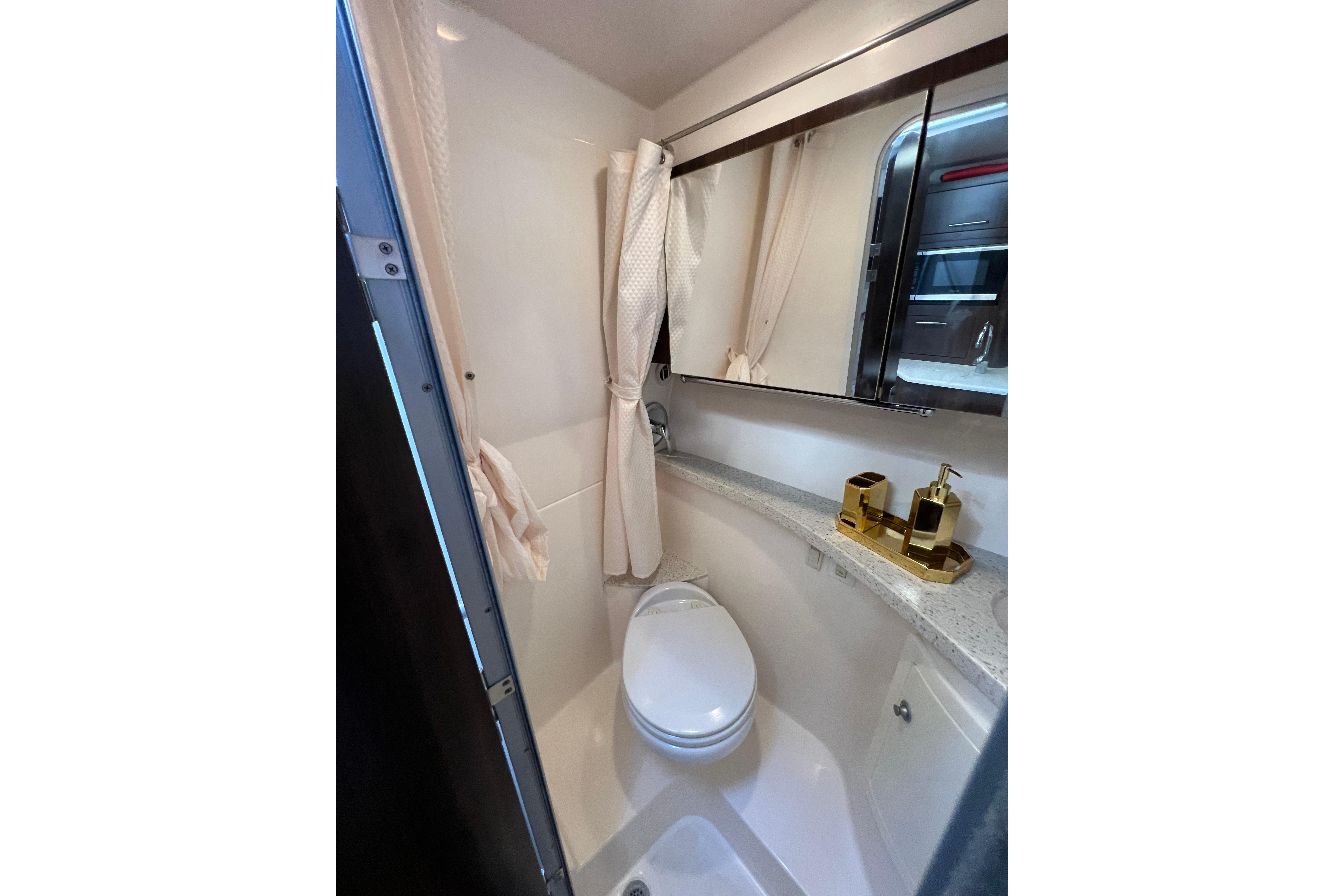 Compact bathroom in 2018 Regal 28 Express boat with modern fixtures and mirror.