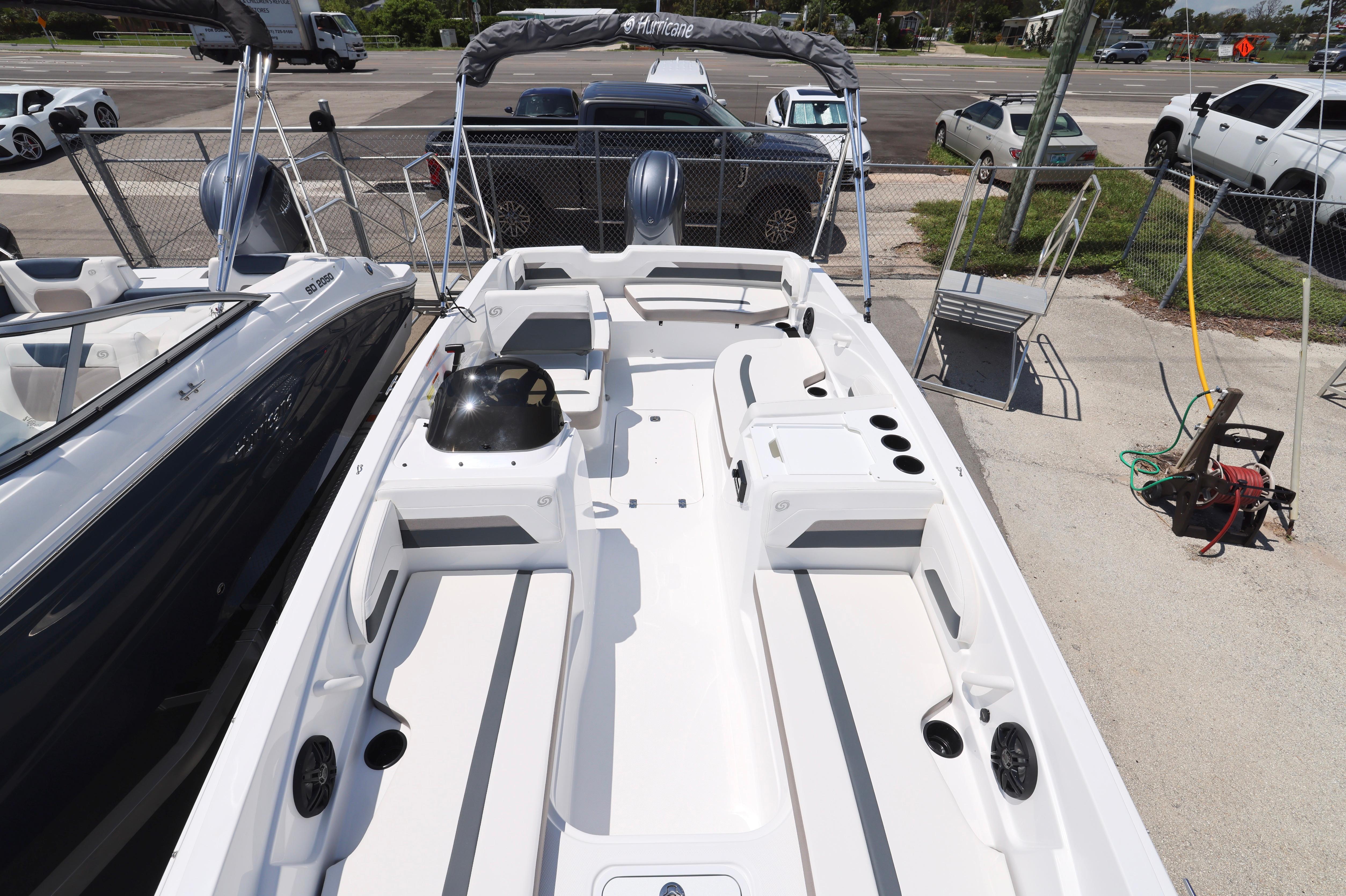 2026 Hurricane SunDeck Sport 205 OB boat, white interior, parked outdoors, showcasing spacious seating.