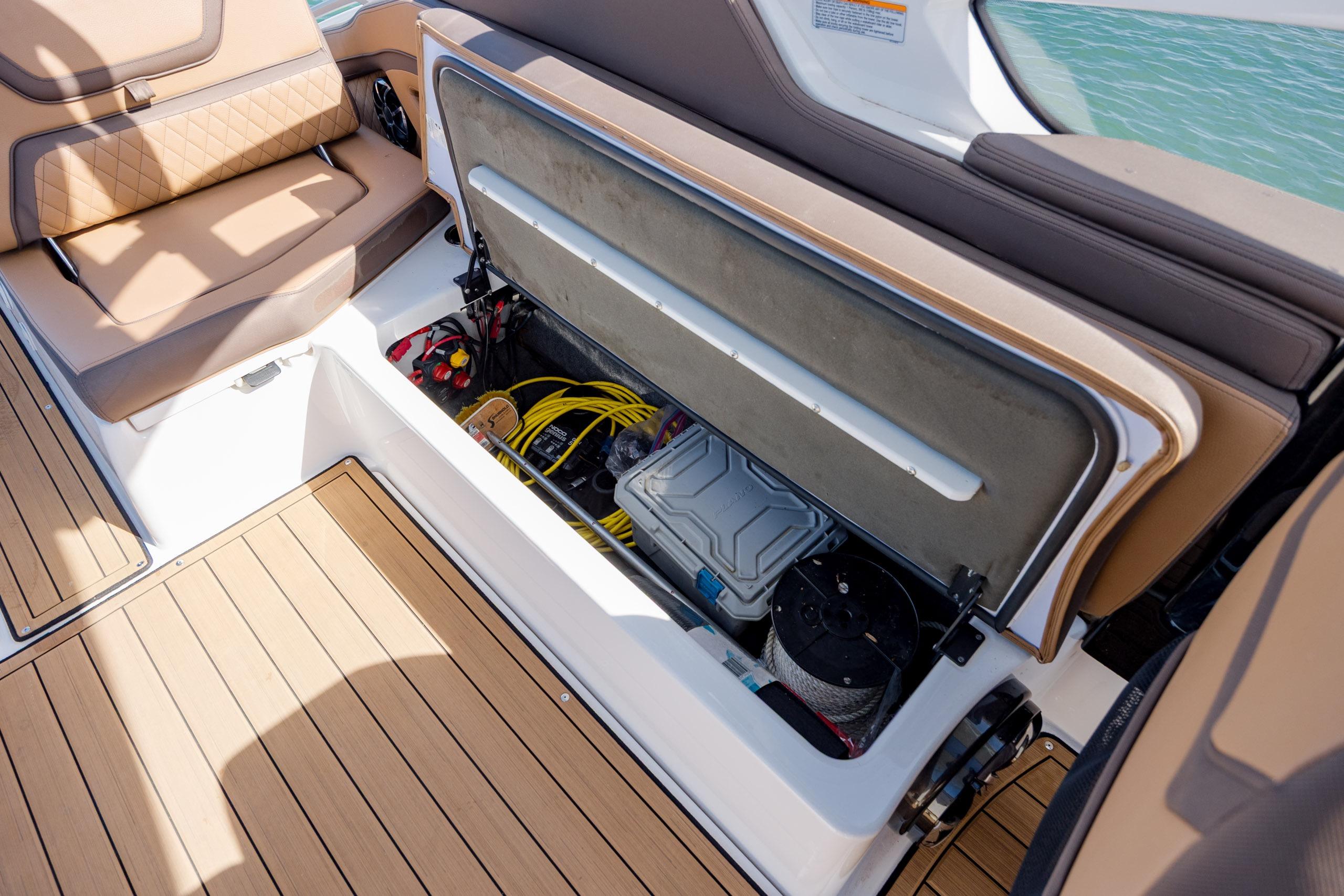 2024 Yamaha Boats 275SD storage compartment with seating and marine equipment.