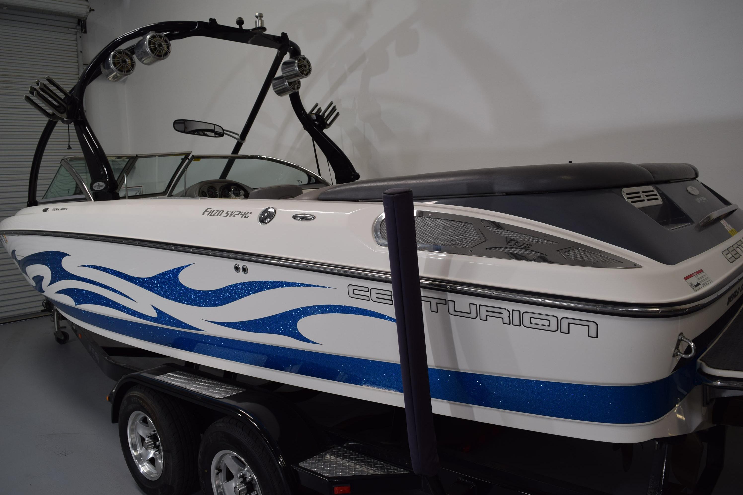 2007 Centurion SV 240 boat with blue wave design, parked indoors on a trailer.
