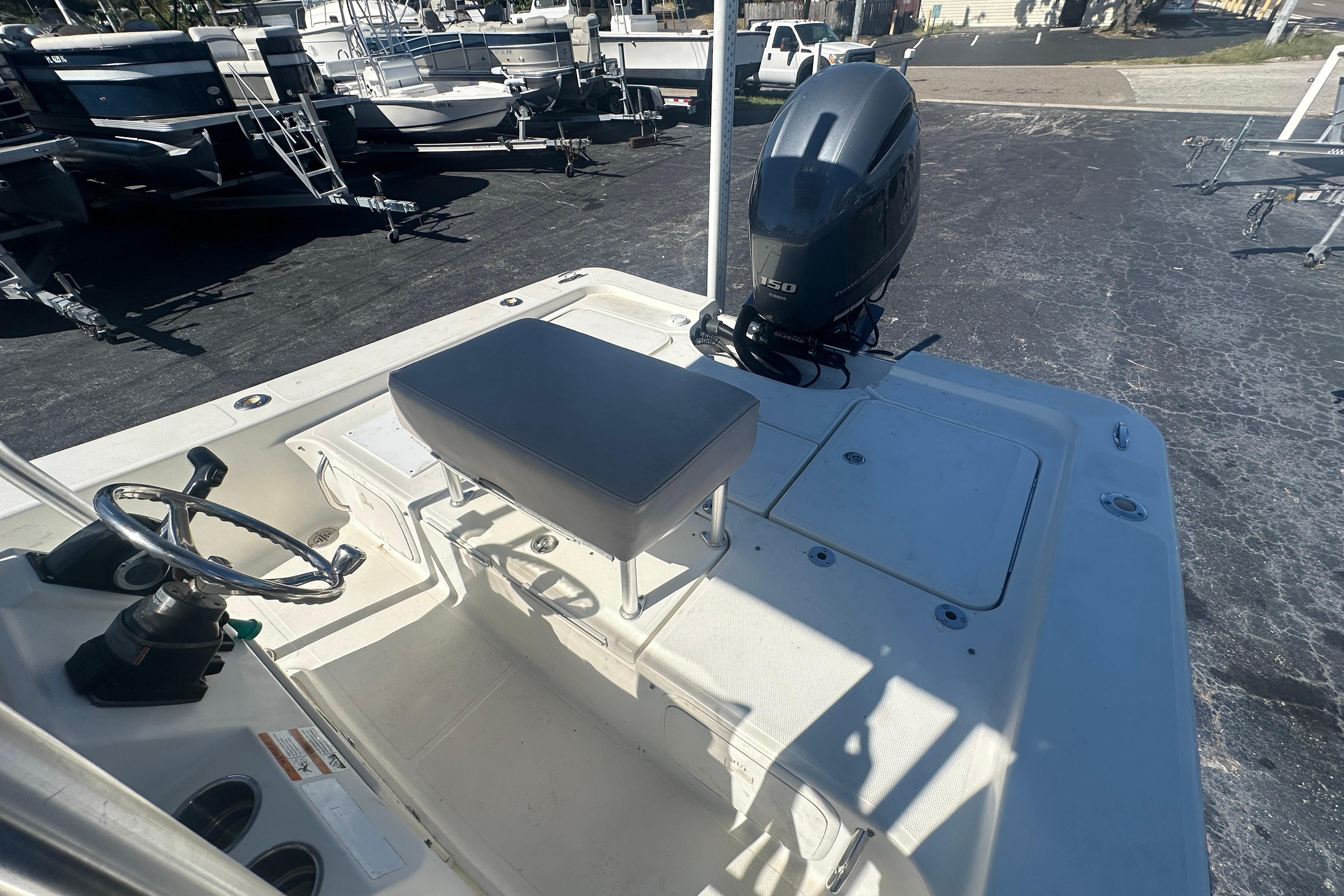 2003 Hydra-Sports 19 Bay Bolt boat with steering wheel and outboard motor in a marina.