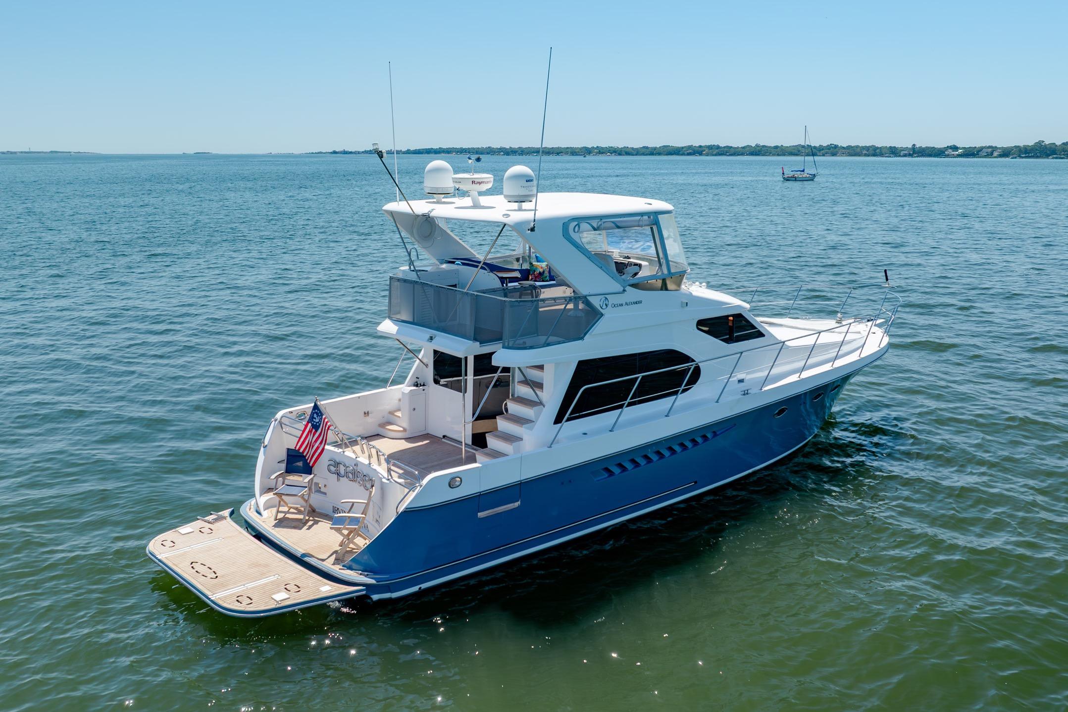 Ocean Alexander yacht cruising on calm waters under clear blue skies.