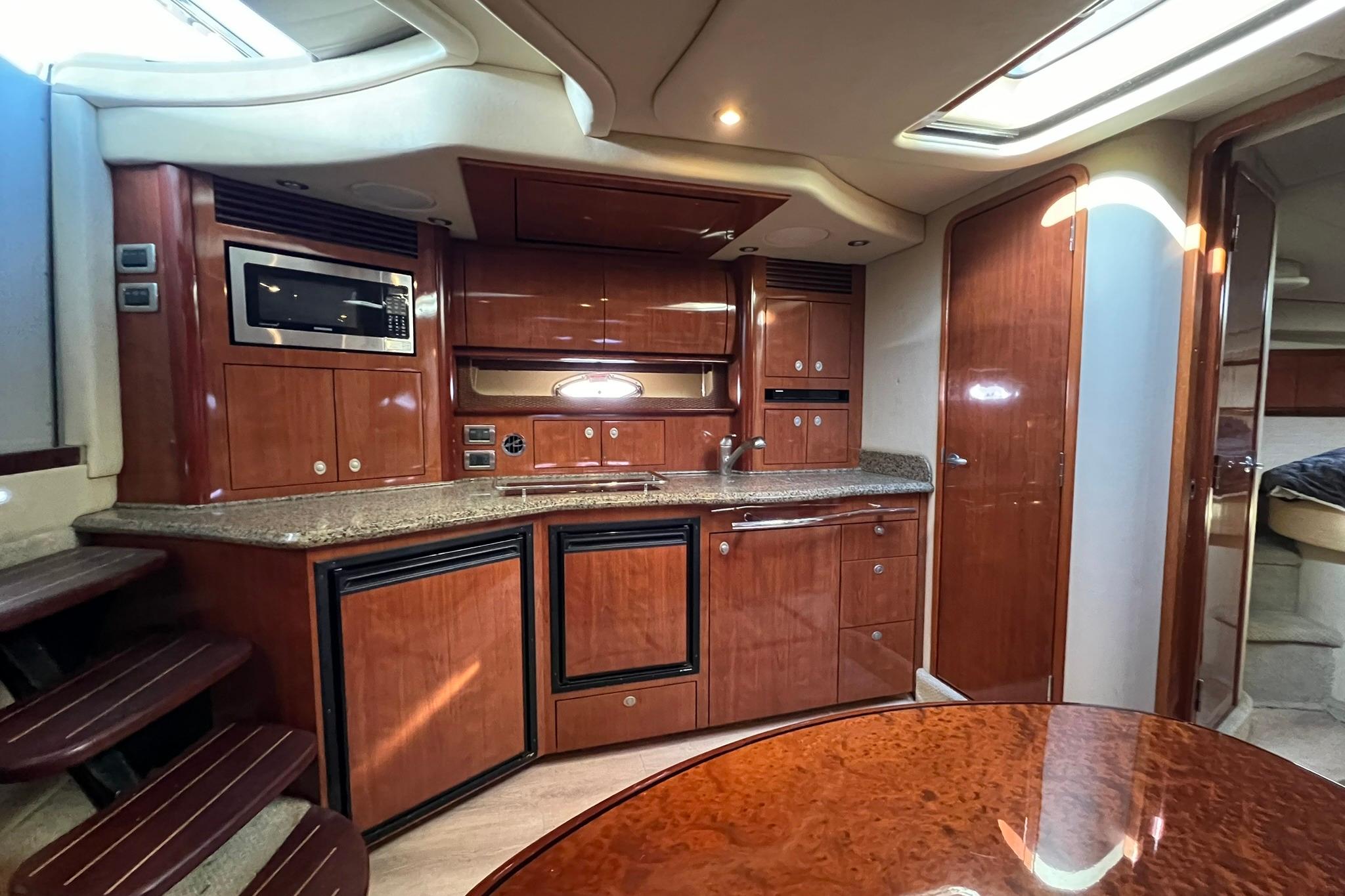 Luxurious 2005 Sea Ray 390 Sundancer yacht interior with modern kitchen and wood finishes.