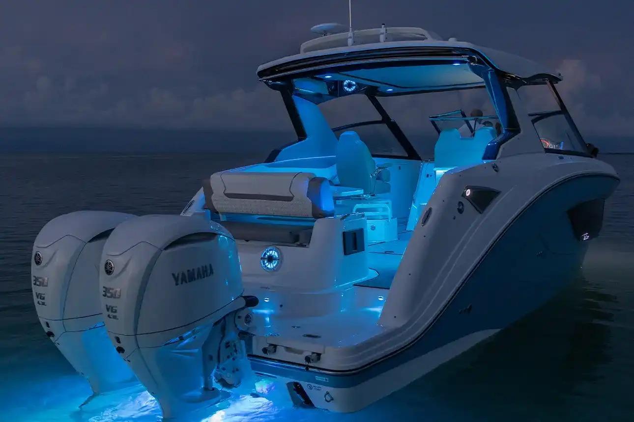 Manufacturer Provided Image: 2026 Hurricane SunDeck 3200 OB boat with illuminated interior and twin Yamaha engines at night.