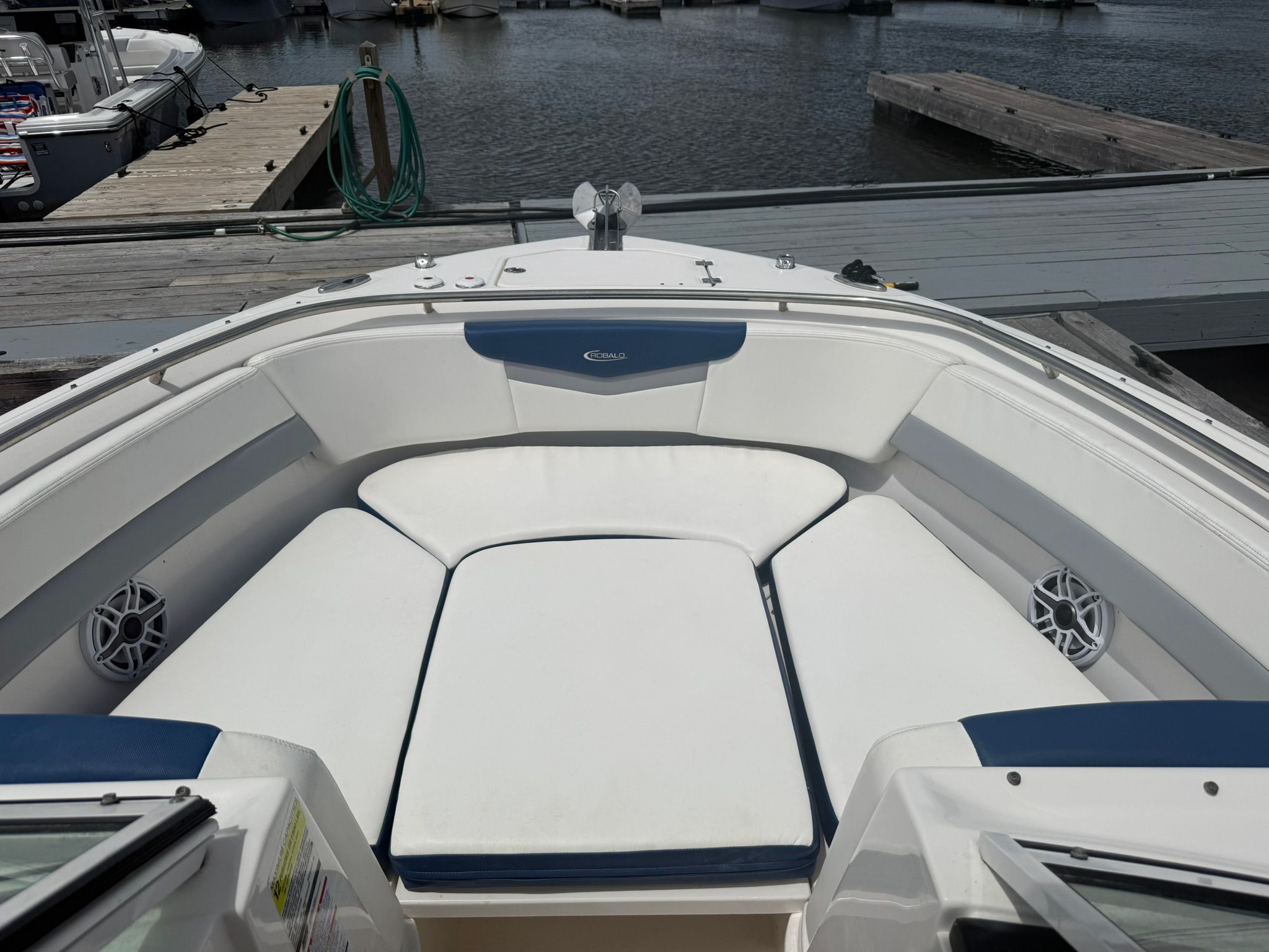 The image shows the bow area of a Robalo R247 Dual Console boat with white cushions.