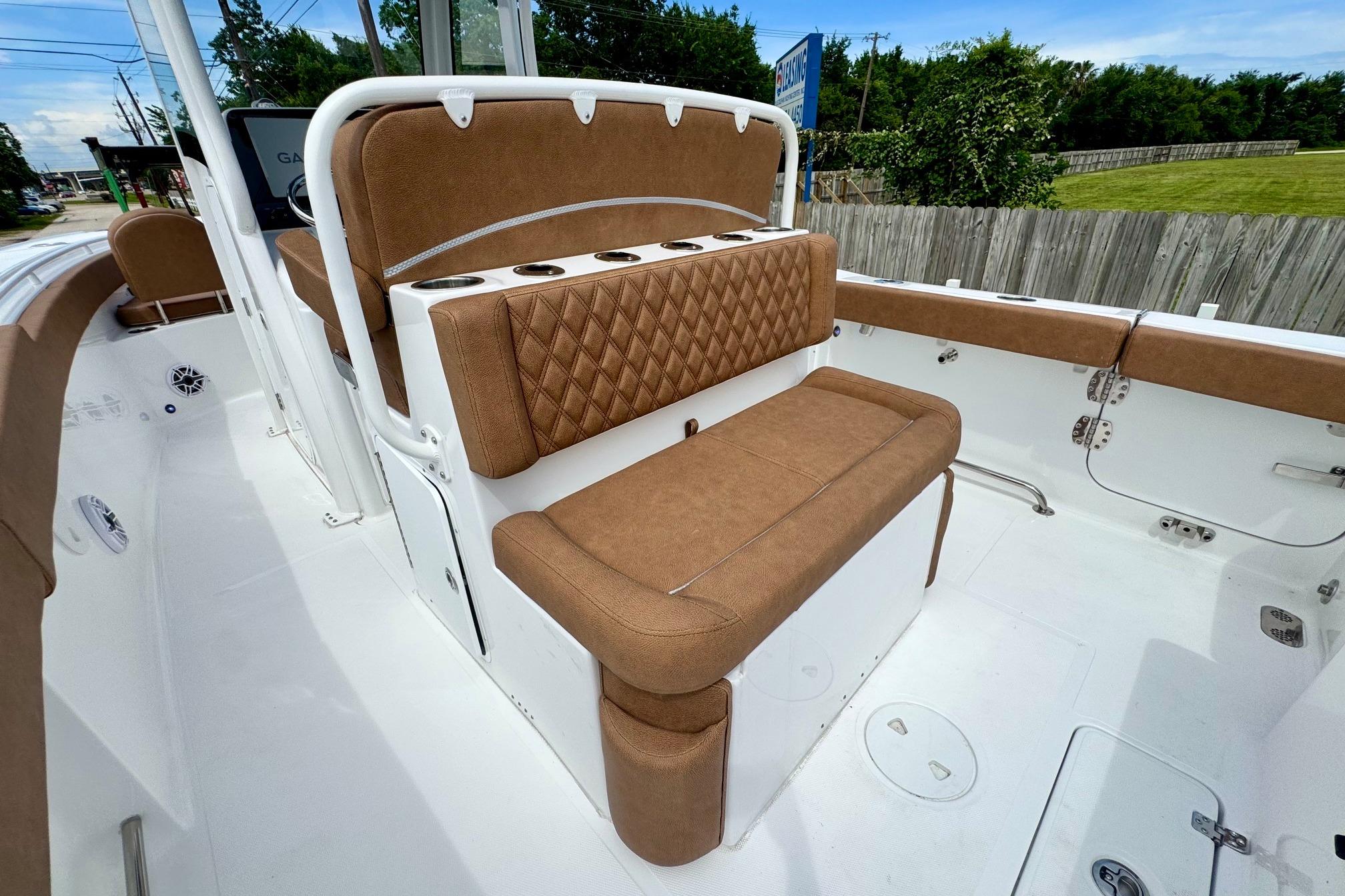 2026 Sea Hunt Ultra 275 SE boat interior with brown cushioned seating and cup holders.