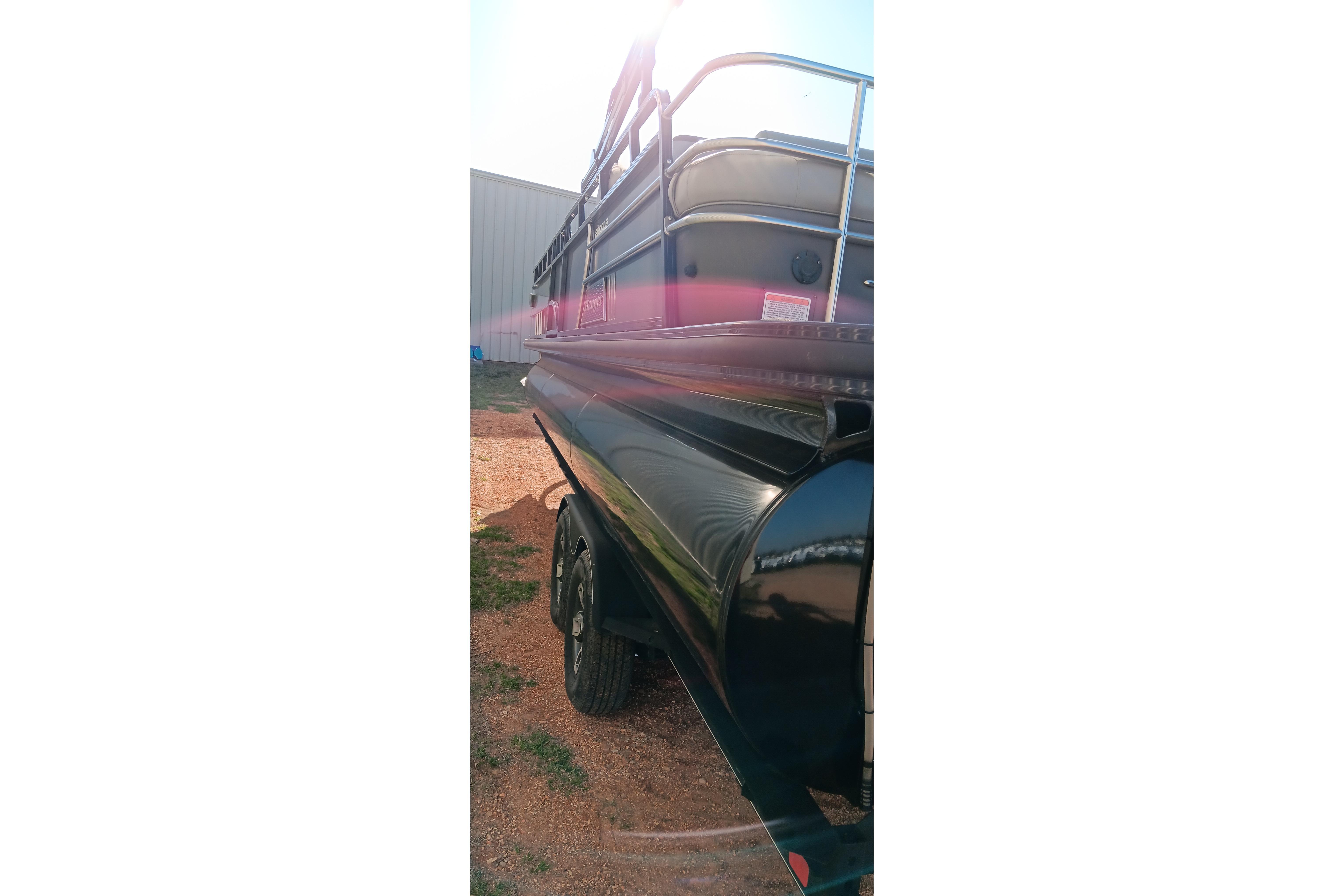 2023 Ranger 2500LS boat with sleek black exterior, parked outdoors in sunlight.