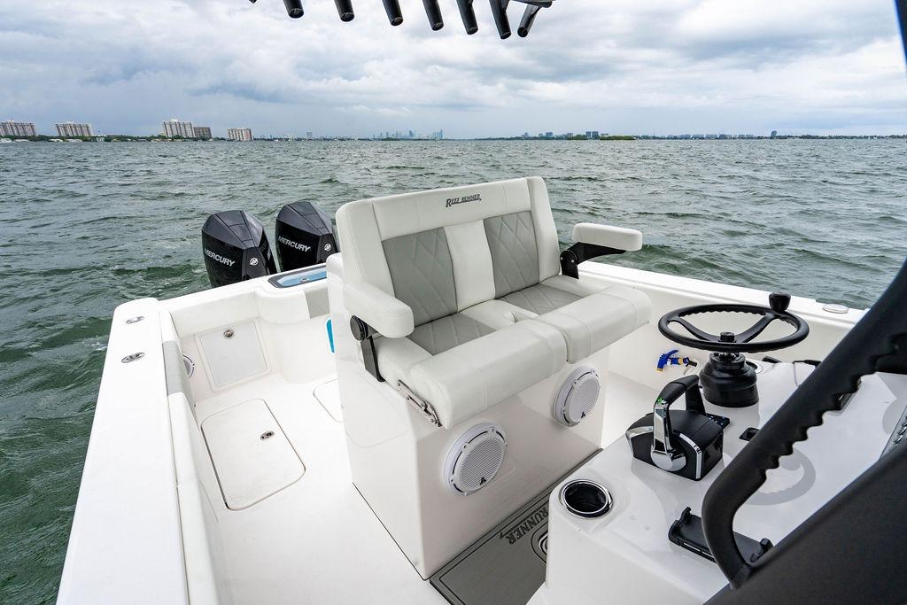 Modern 2027 Reef Runner 280 boat interior with dual Mercury engines on open water.