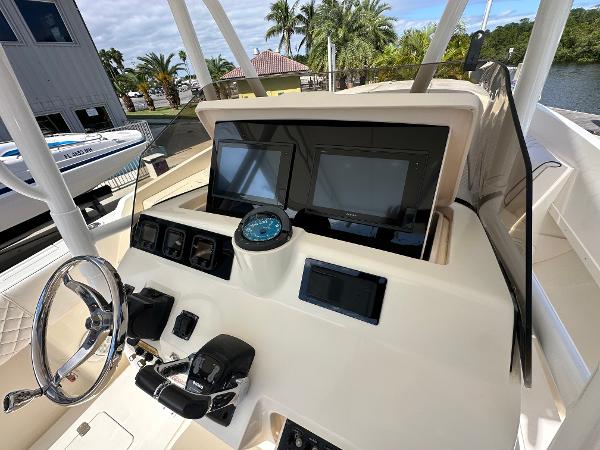 2005 Intrepid 323 boat dashboard with steering wheel and navigation screens.