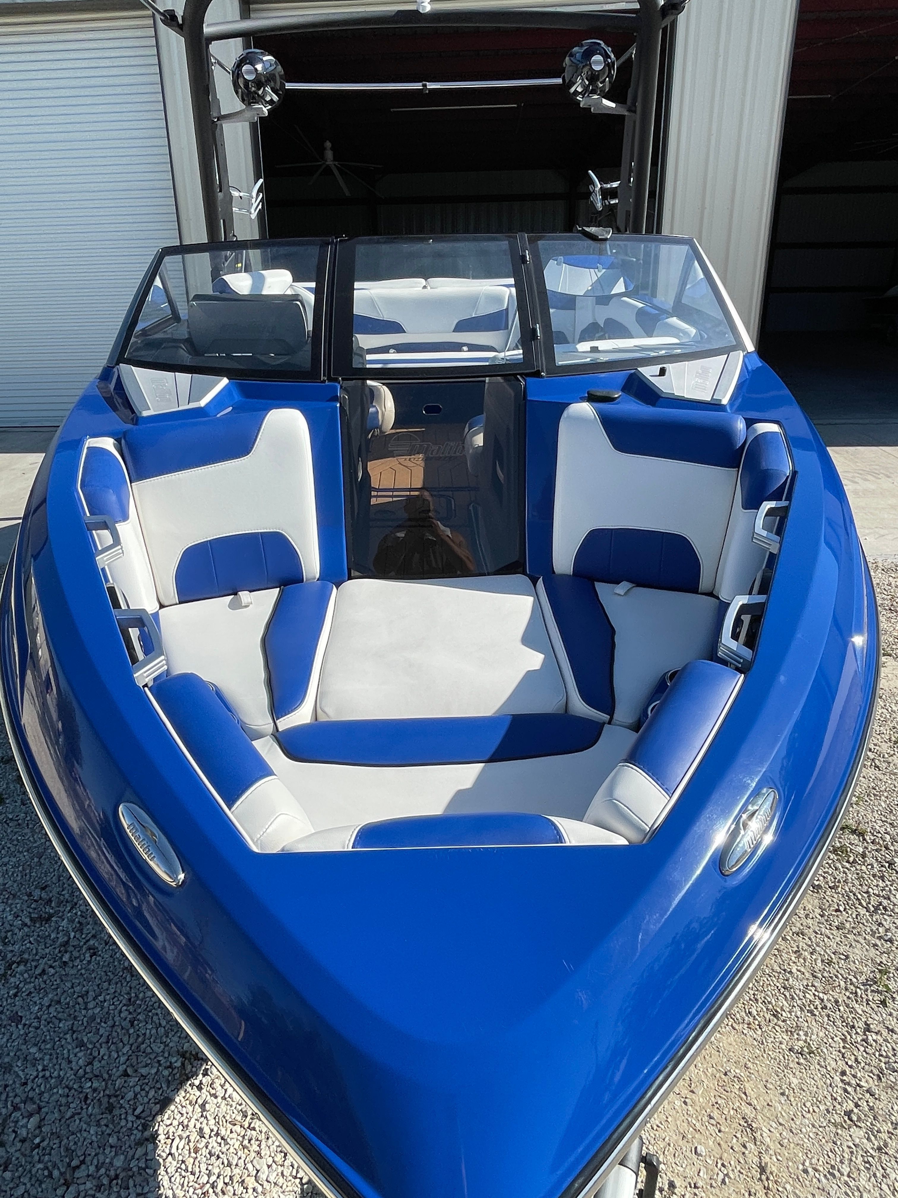 A blue 2019 Malibu Wakesetter 22 LSV with white and blue seats, parked in a garage.