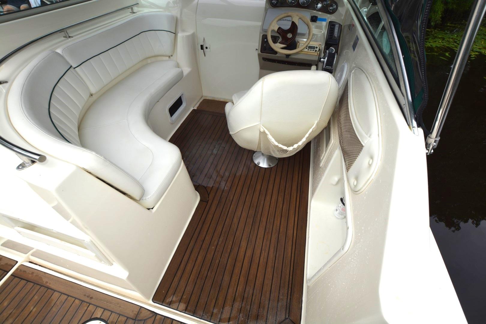 1999 Rinker 270 Fiesta Vee boat interior with white seating and wooden flooring.