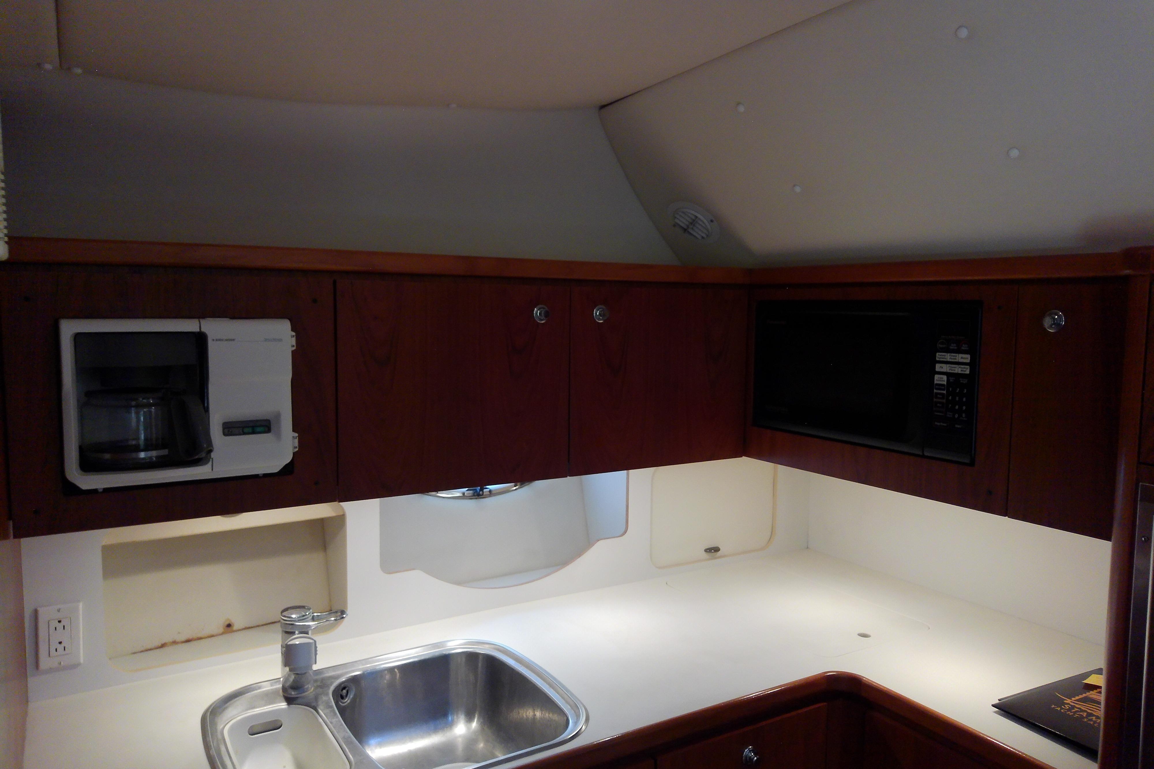 Kitchen area of a 2000 Tiara Yachts 4100 Open with sink, microwave, and coffee maker.
