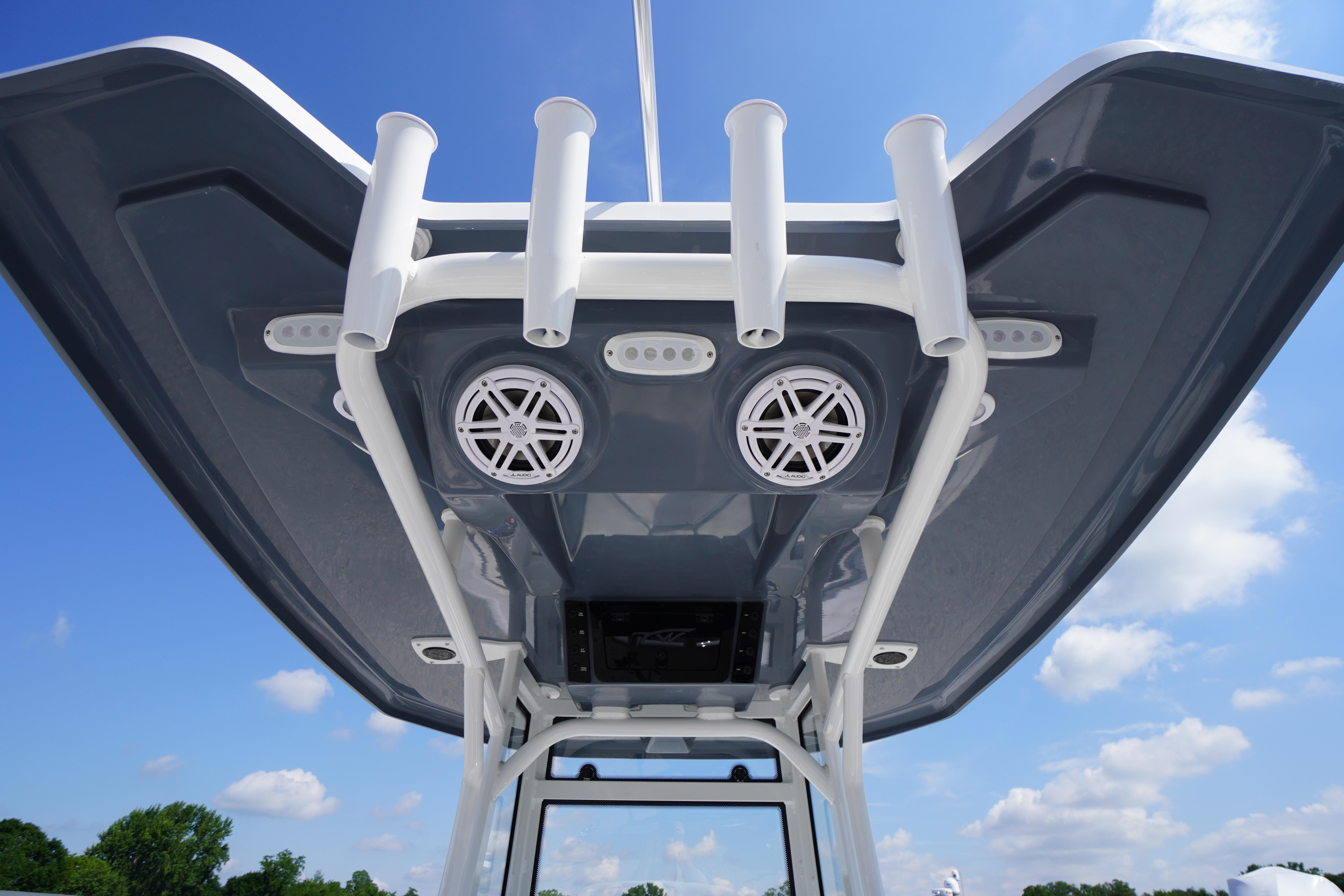 Tidewater 220 CC Adventure 2026 boat roof with speakers and rod holders under blue sky.