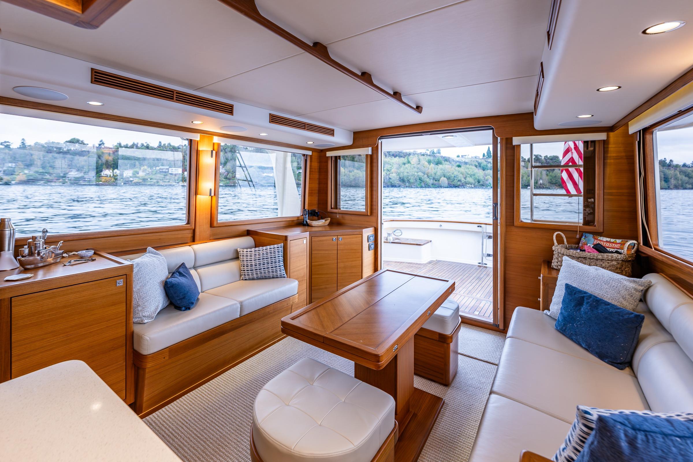 Luxurious interior of 2026 Fleming 55 Pilothouse yacht with elegant wood finish and waterfront view.