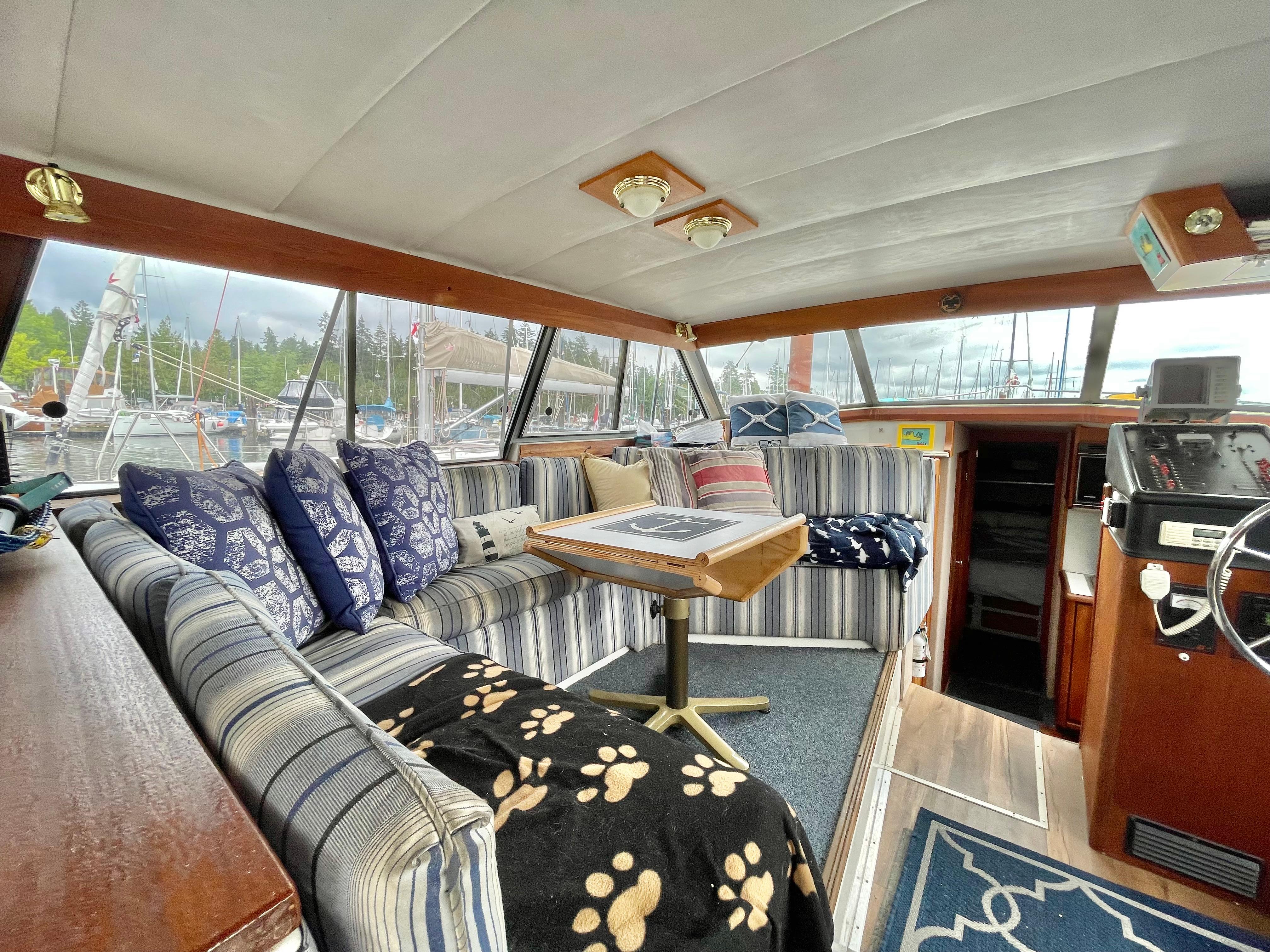 Interior of 1987 Bayliner 3870 Motoryacht with striped seating, cushions, and nautical decor.