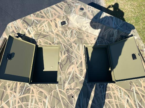 2025 Lowe Roughneck 2070 SC boat with open storage compartments, camo design.