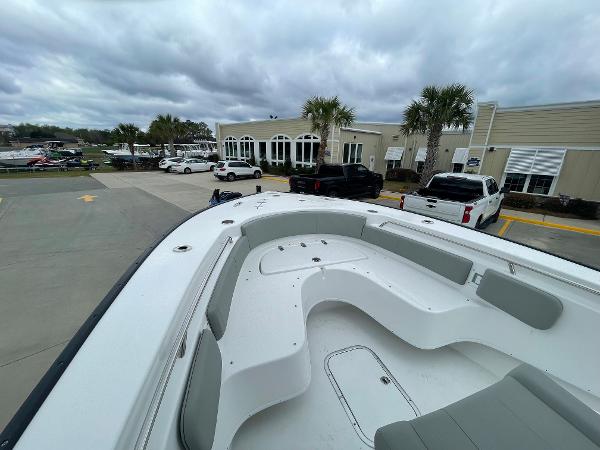 2026 Cape Horn 24XS boat with spacious seating, parked near a building under cloudy skies.