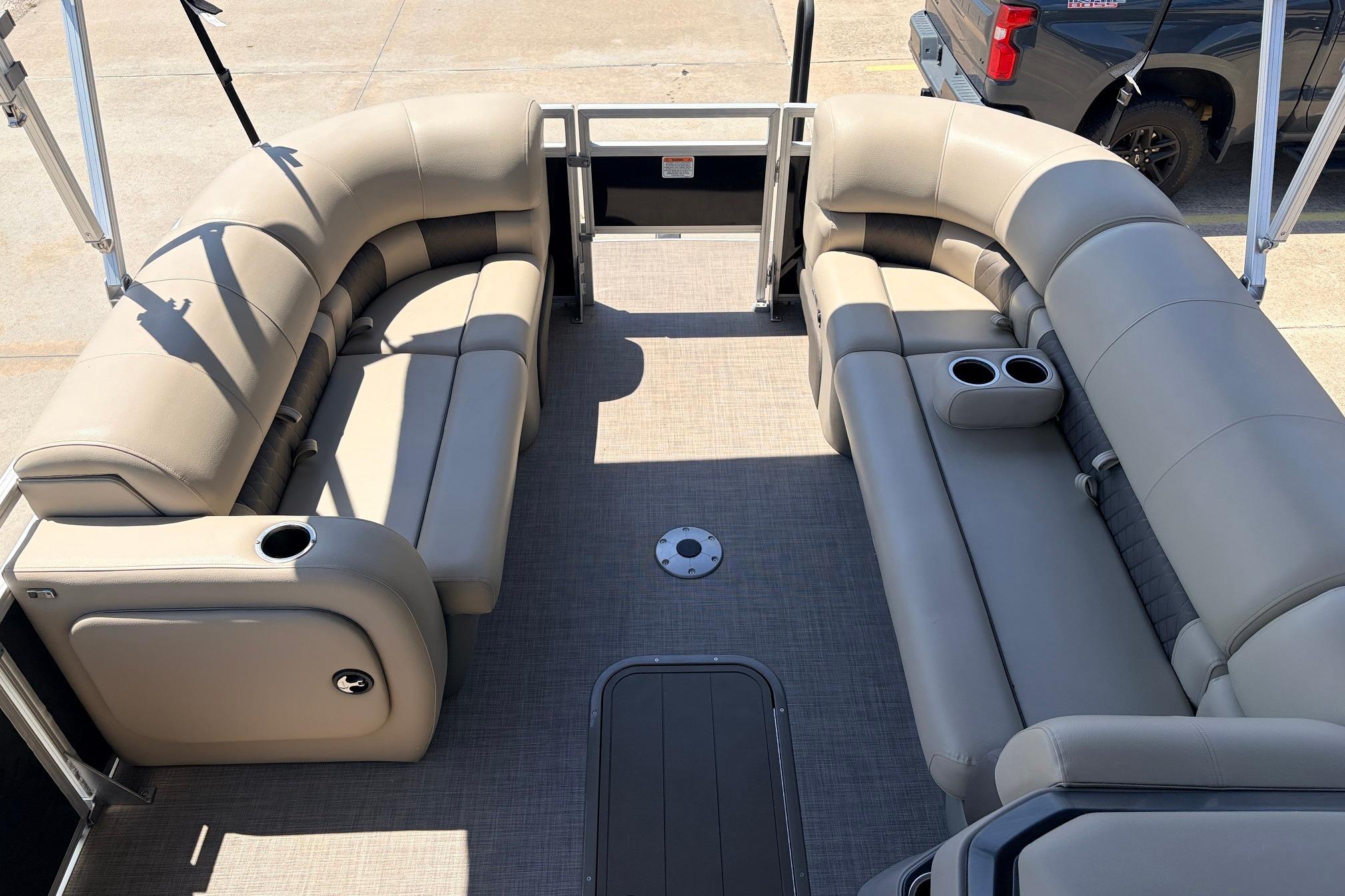 2024 Sun Tracker SportFish 22 XP3 pontoon boat interior with beige seating and cup holders.