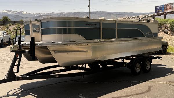 2023 SunCatcher Select 322FC pontoon boat on a trailer, parked outdoors.