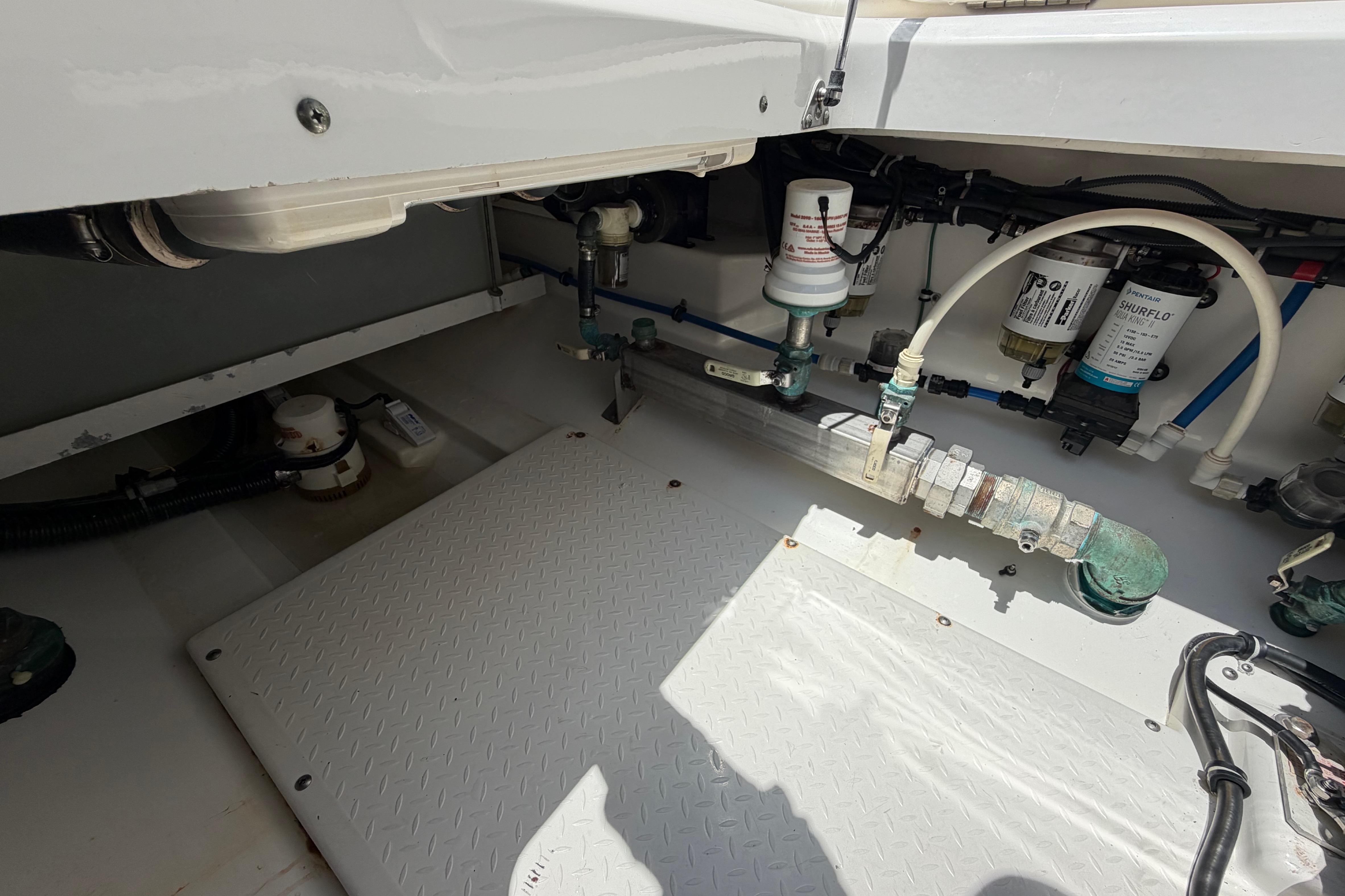 Engine compartment of a 2009 Everglades 350LX boat, showcasing plumbing and filtration systems.