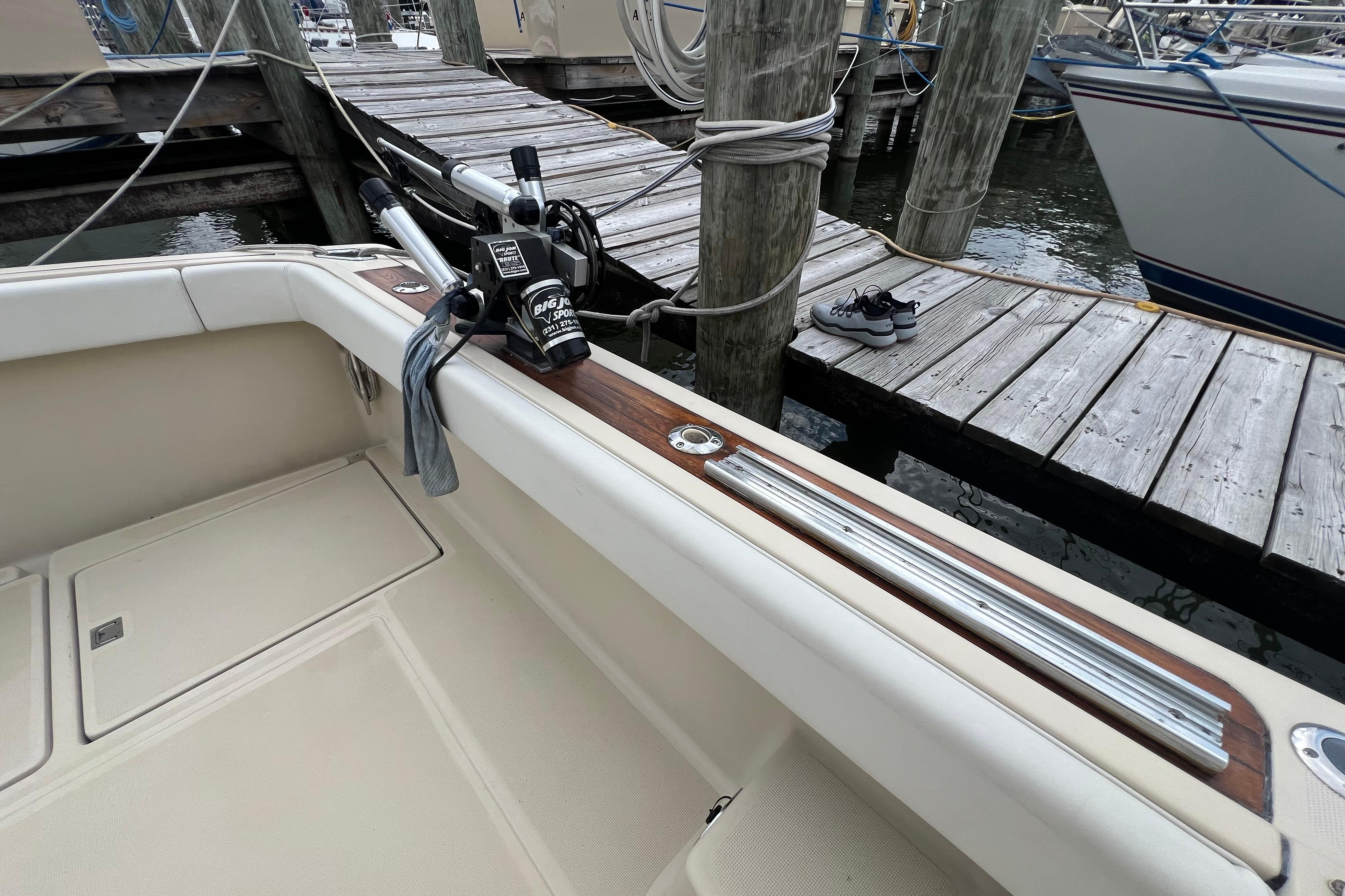 1985 Tiara 36 OPEN boat docked, featuring fishing rod holders and wooden trim.