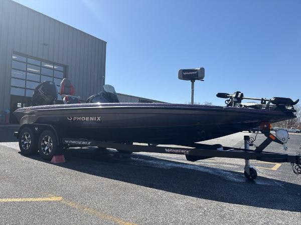 2025 Phoenix 920 Elite boat on trailer, parked outside a building.
