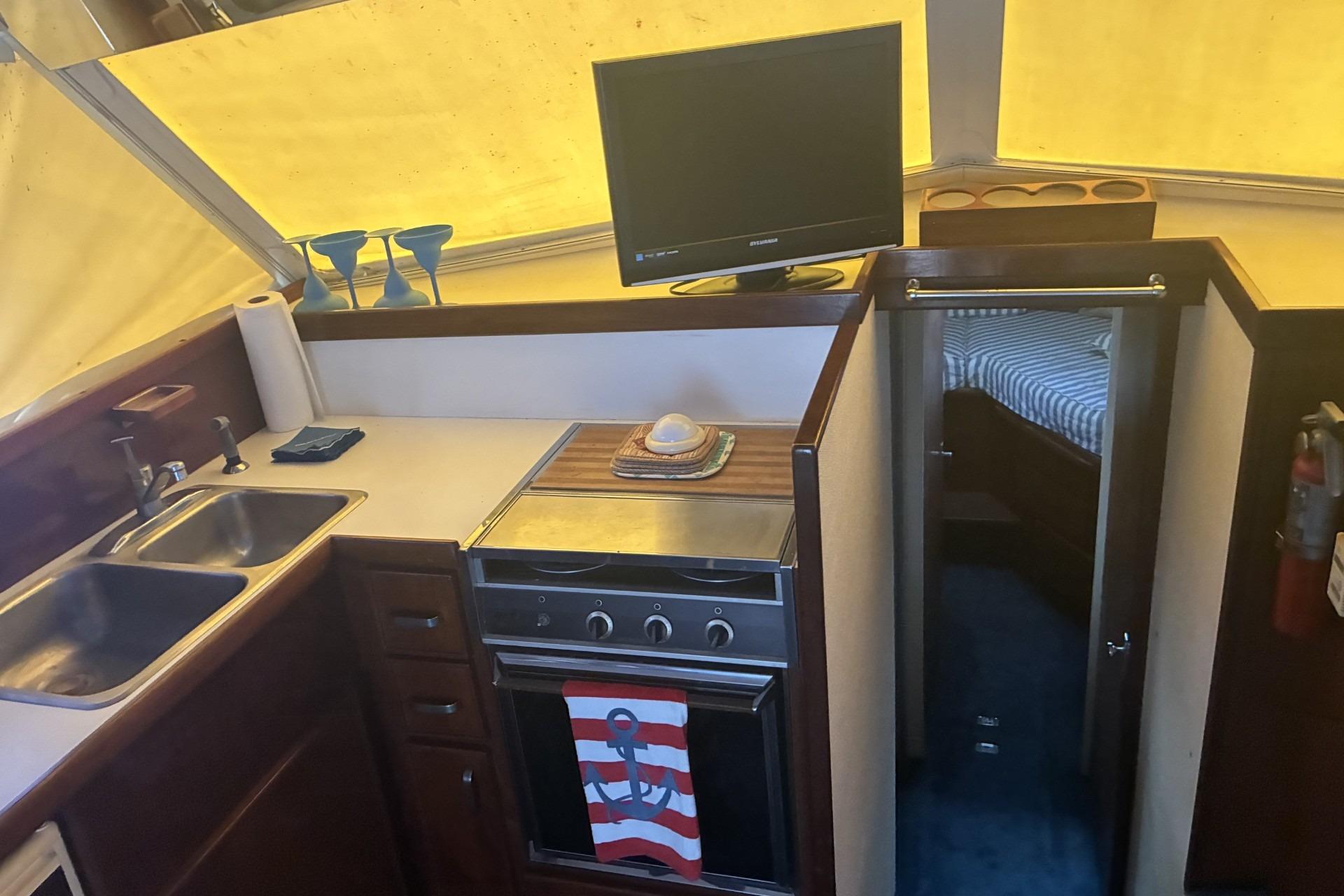 Interior of 1980 Chris-Craft 360 Commander with kitchen, TV, and cabin entrance.