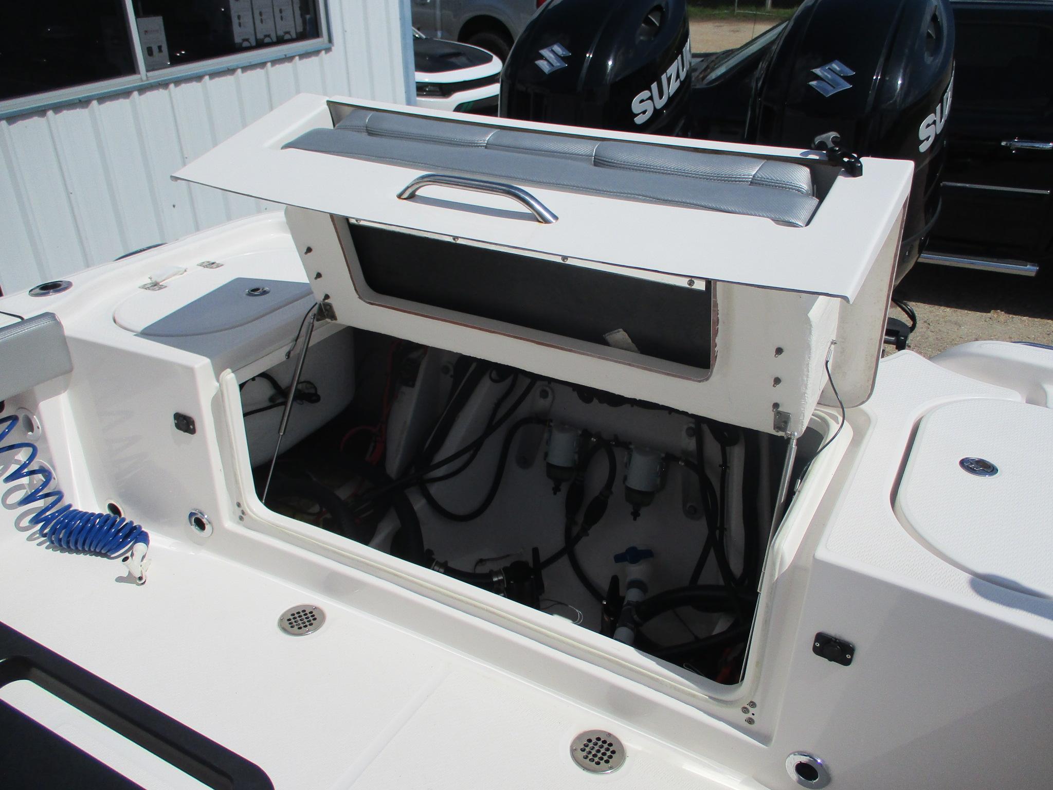 2024 Blue Wave 2800 Makaira boat with open storage compartment and visible engine components.