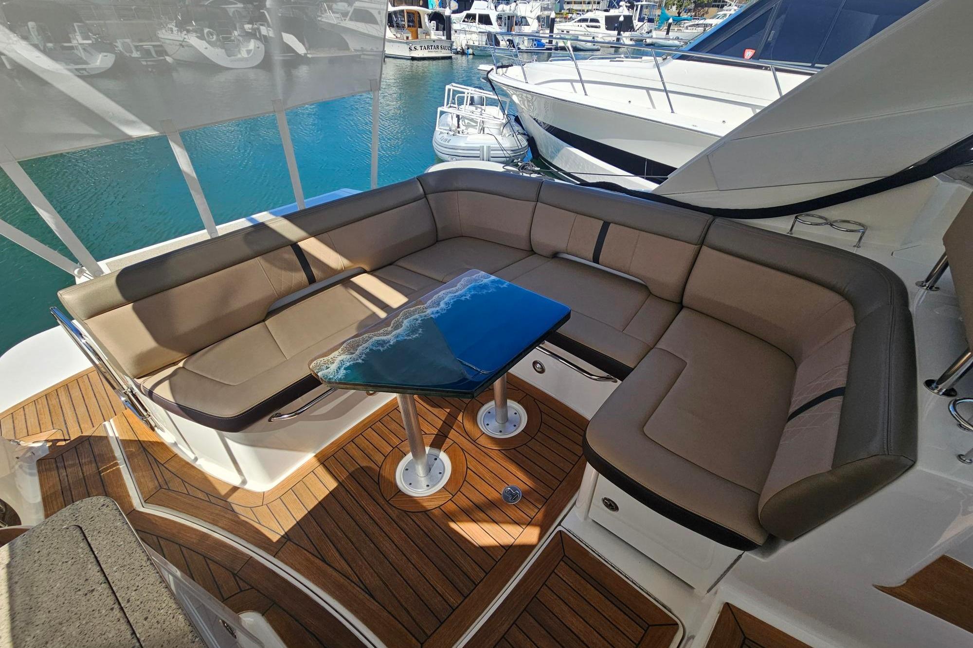 Luxurious seating area on 2016 Sea Ray Sundancer 350 yacht with elegant wooden deck.