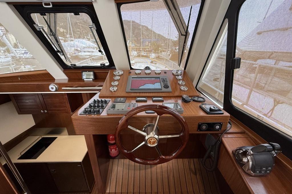Interior helm of 2012 Sasga Yachts Menorquin 42 with wooden dashboard and navigation equipment.