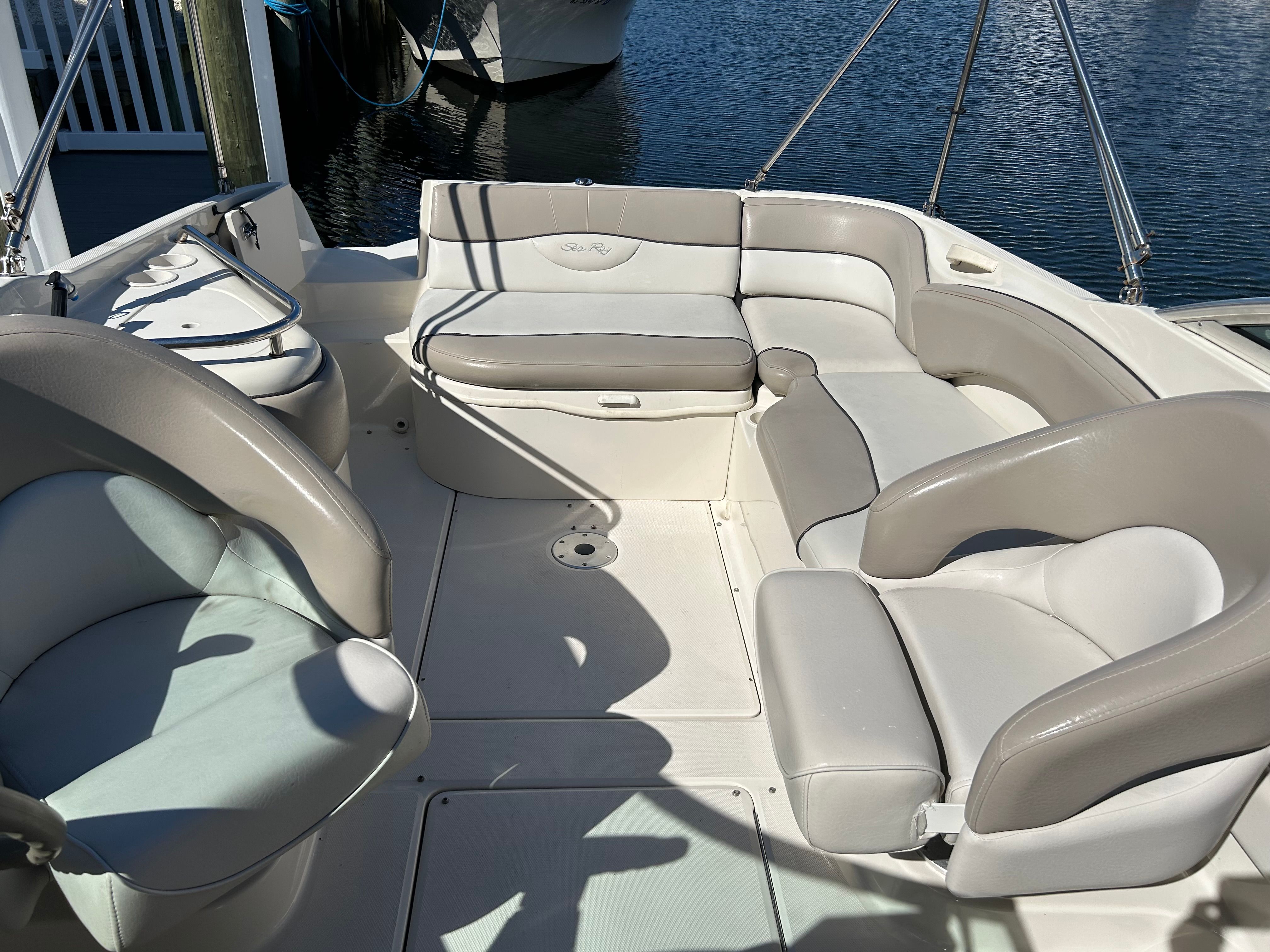 Interior of a 2003 Sea Ray 240 Sundeck boat by the water.
