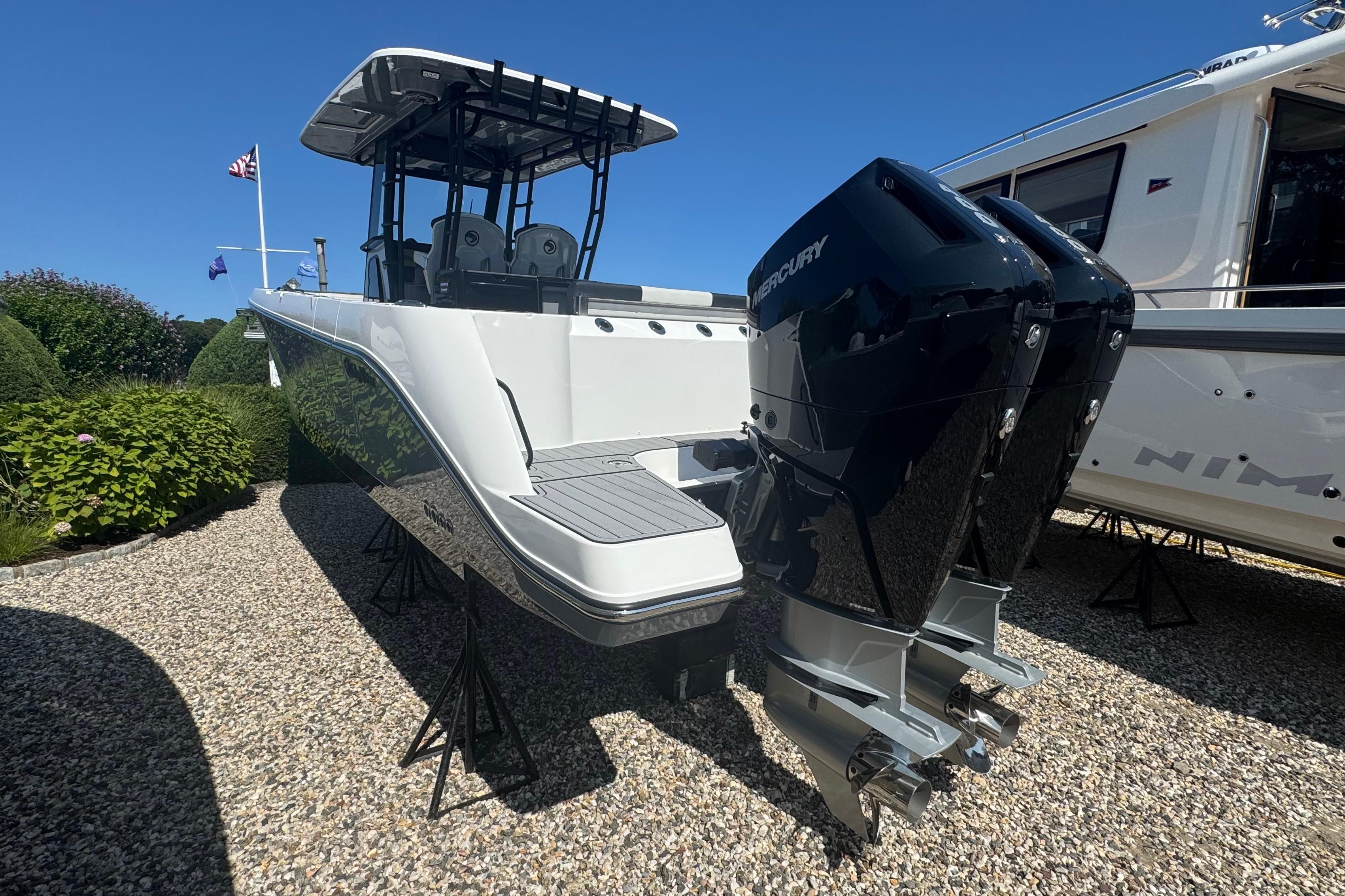 2025 Edgewater 340CC boat with dual Mercury engines on display outdoors.
