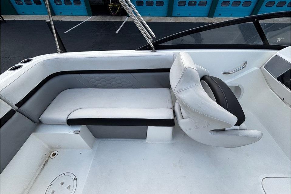2022 Hurricane SunDeck 217 OB boat interior with white seating and steering area.