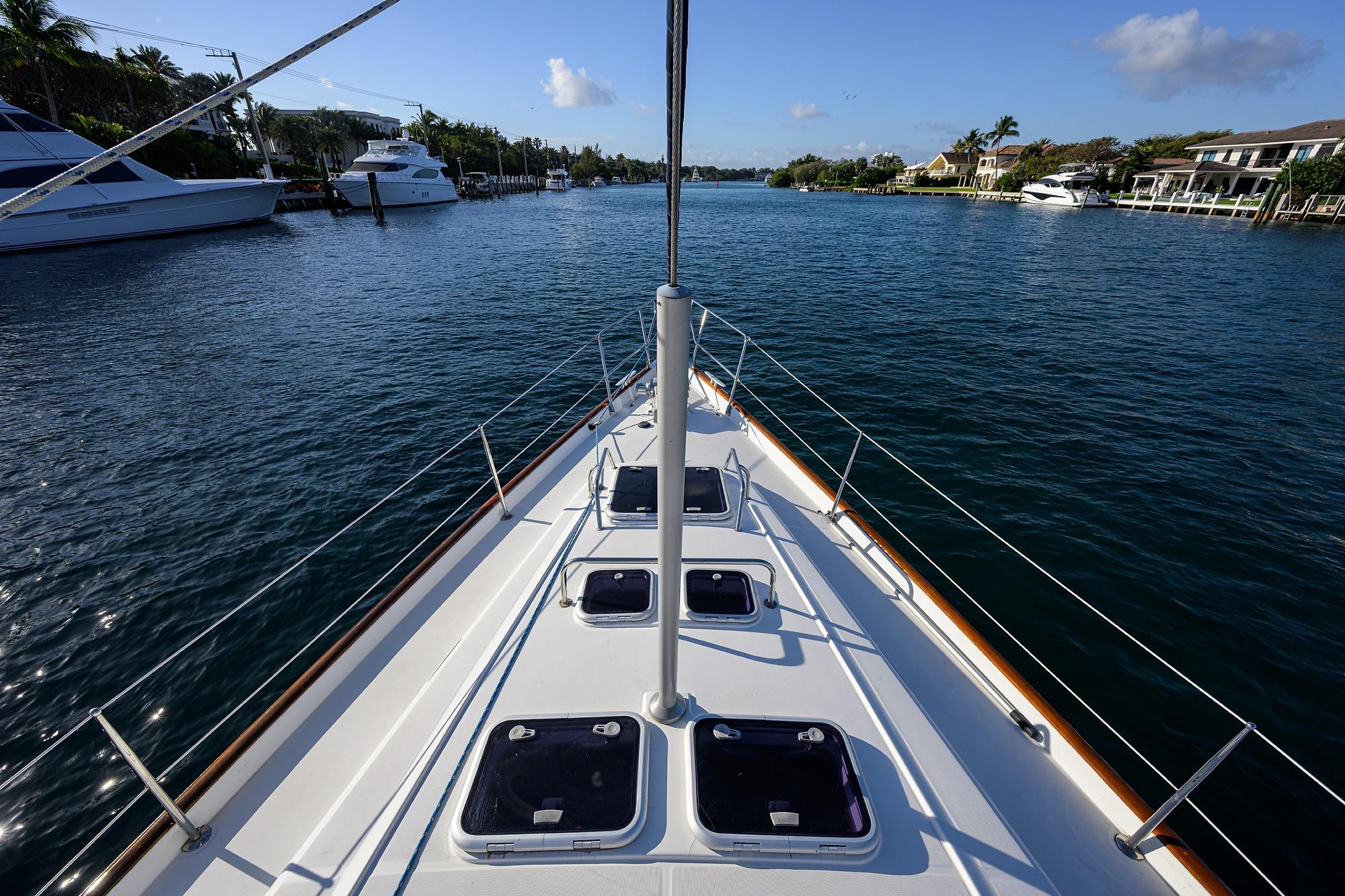 Bow view of 2003 Beneteau 50 yacht navigating a serene waterway.