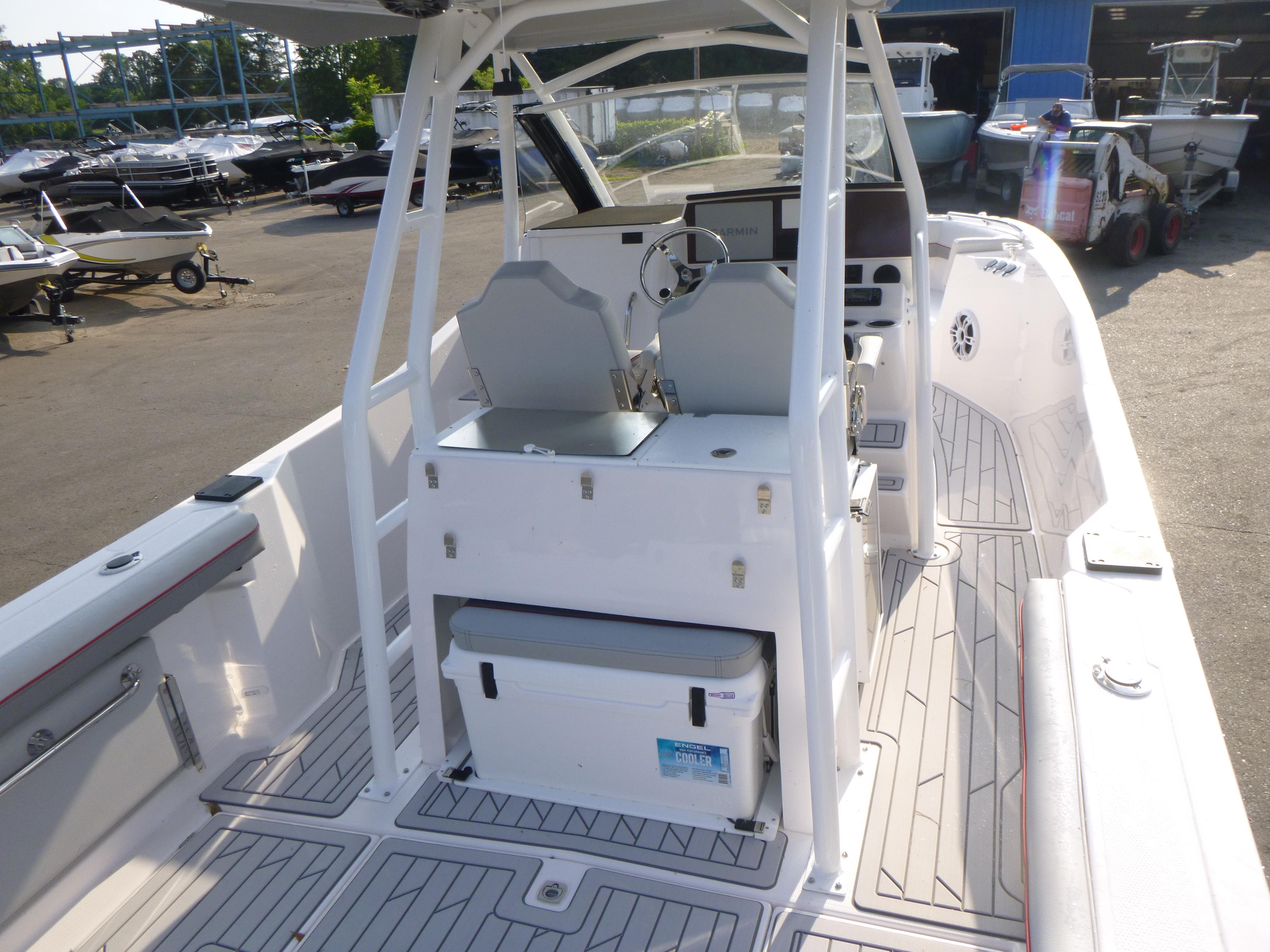 2025 Solara S-250 CW boat interior with modern helm, seating, and storage in a marina setting.