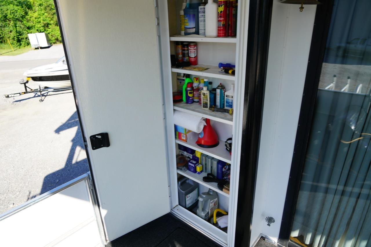 Storage cabinet on a 2000 Stardust Cruisers houseboat, stocked with various maintenance supplies.