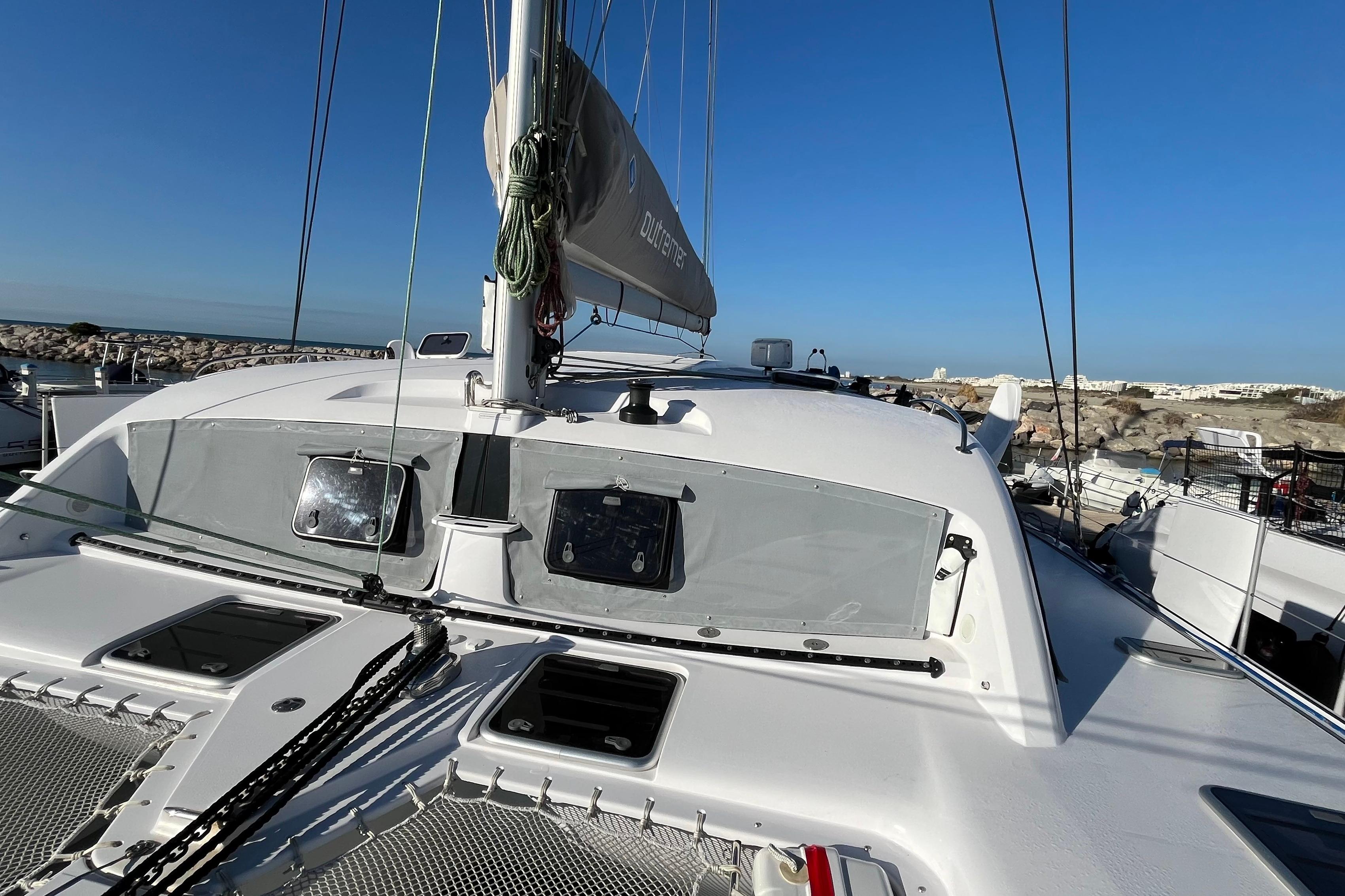 2024 Outremer 45 catamaran deck with clear sky and marina view.