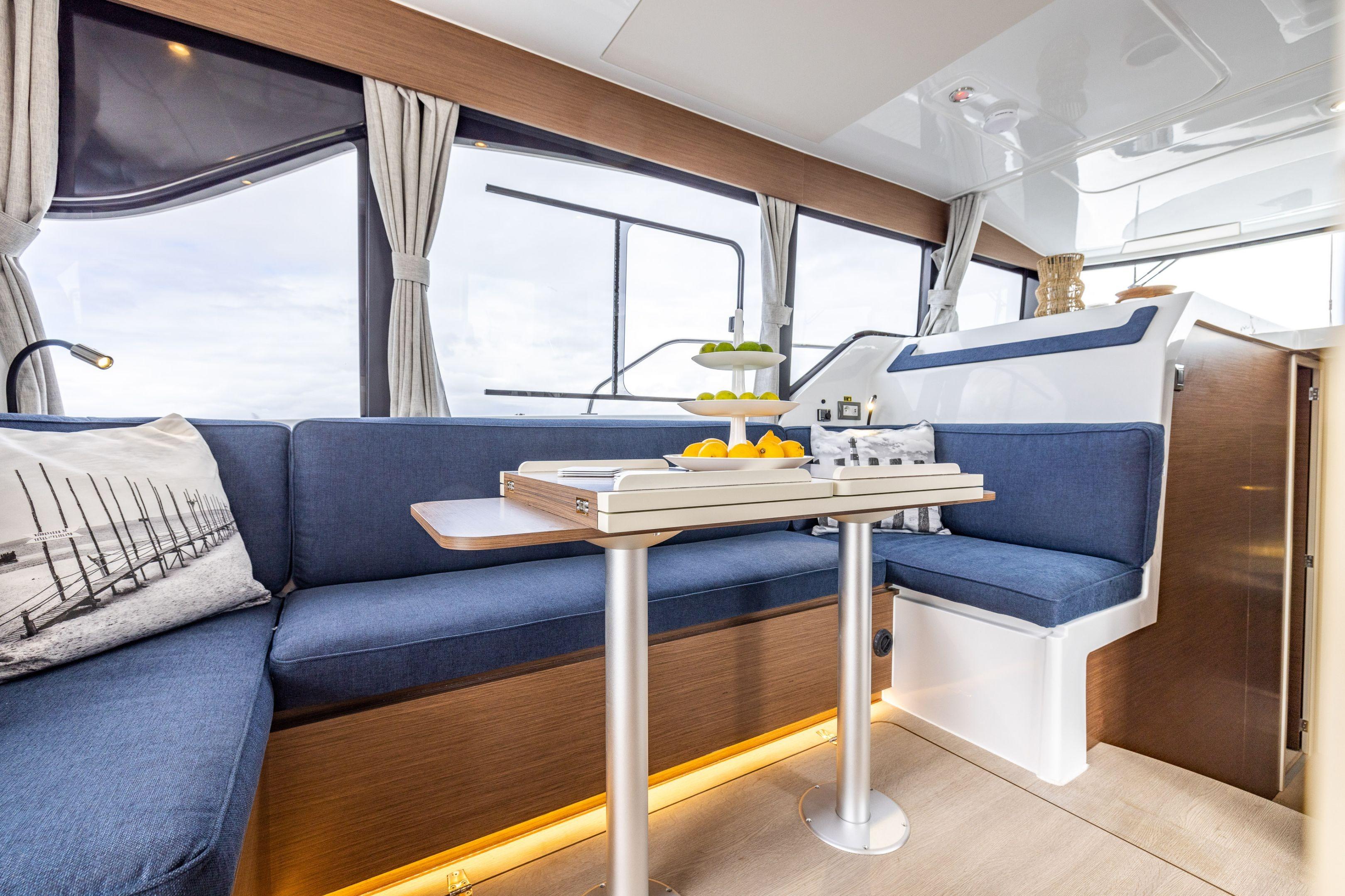 Luxurious interior of 2026 Delphia D11 Flybridge yacht with blue seating and elegant decor.
