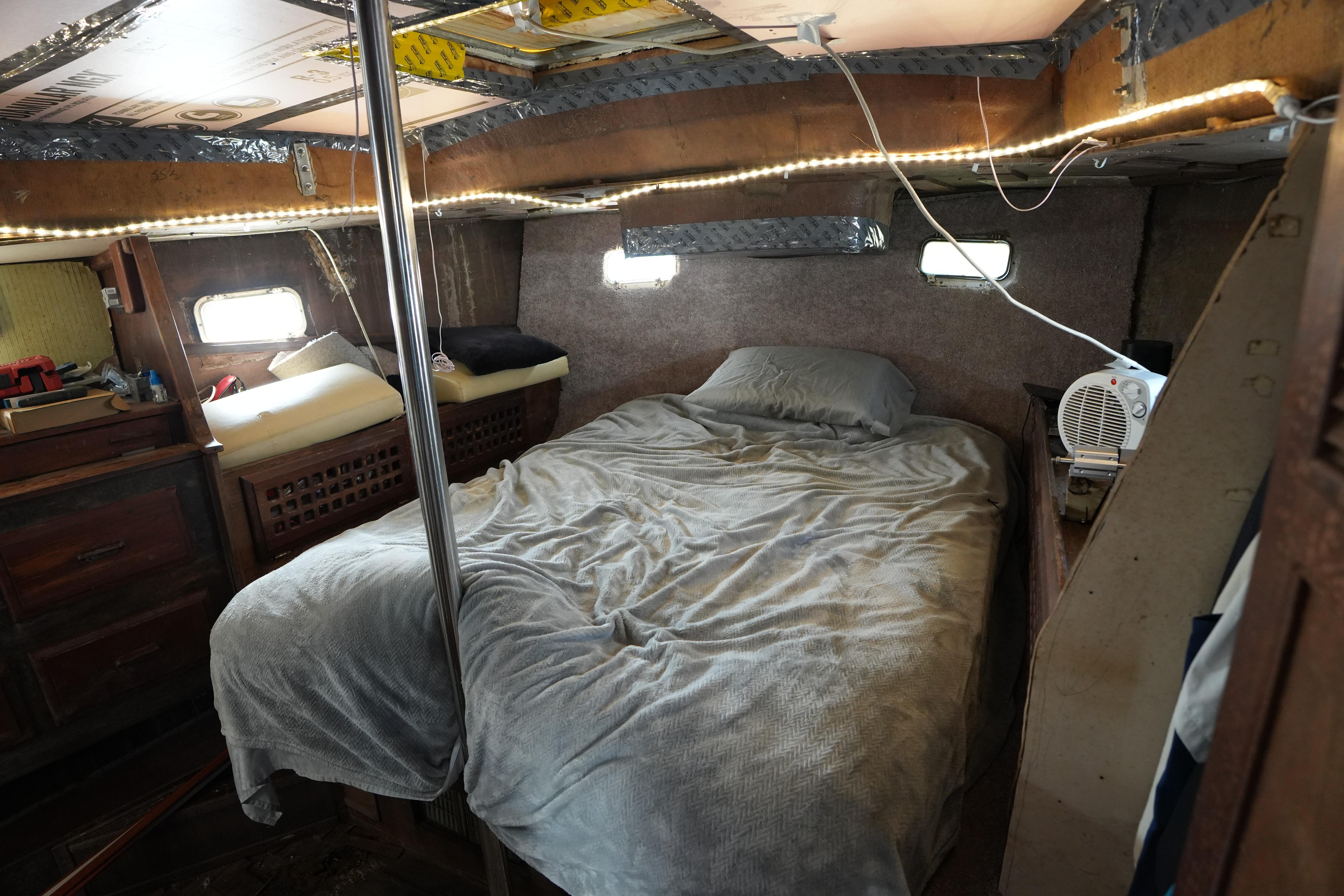 Cozy cabin interior of 1990 Endeavour 43 Center Cockpit sailboat with bed and portholes.